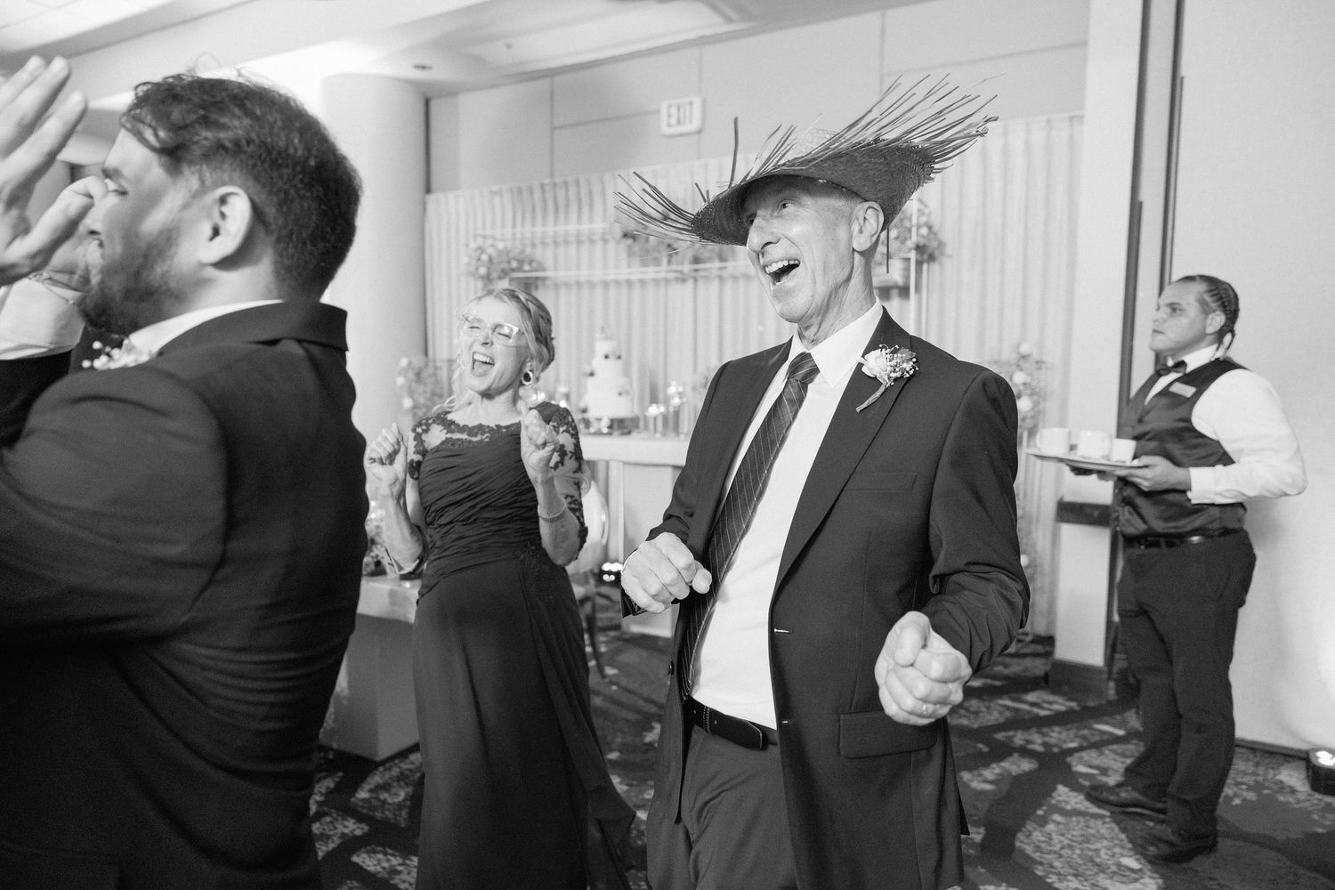 Wedding party members dance and celebrate together during a reception party.