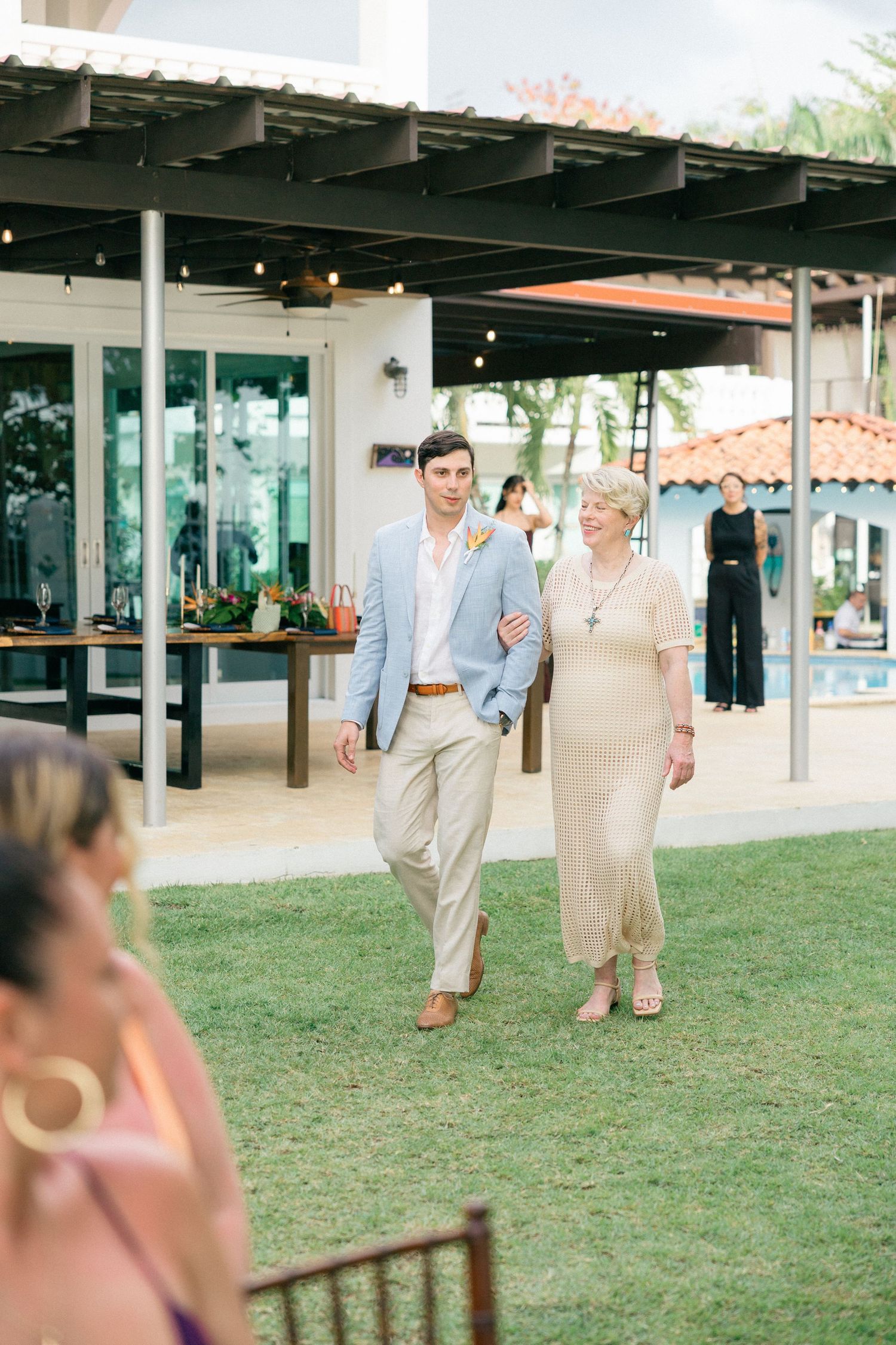 Outdoor wedding ceremony entrance with covered patio and manicured lawn.