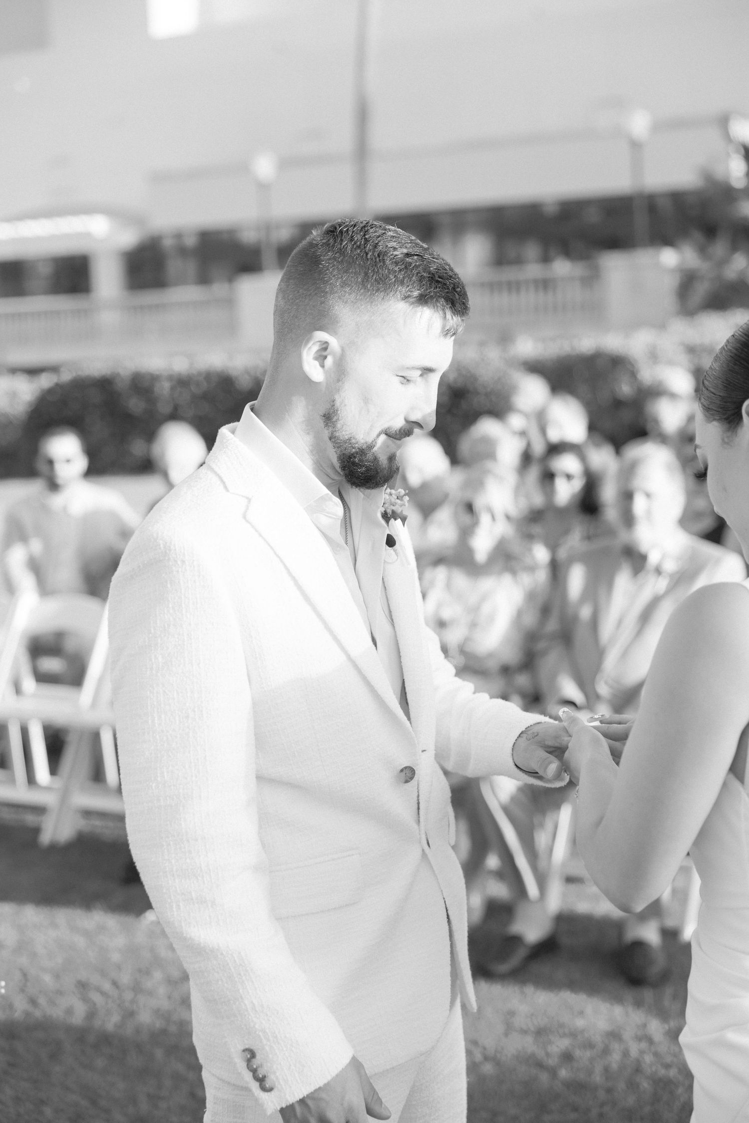 Wedding guests in white attire gathered at an outdoor reception.
