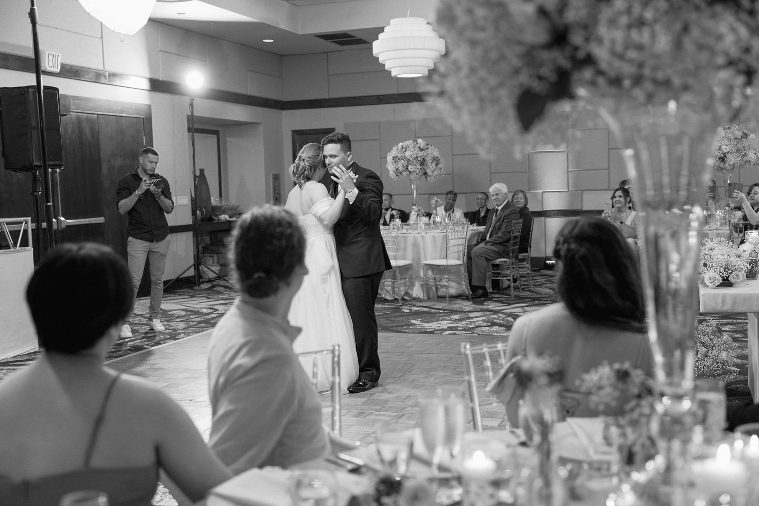 Candlelit reception venue with guests watching the couple's dance from decorated tables.