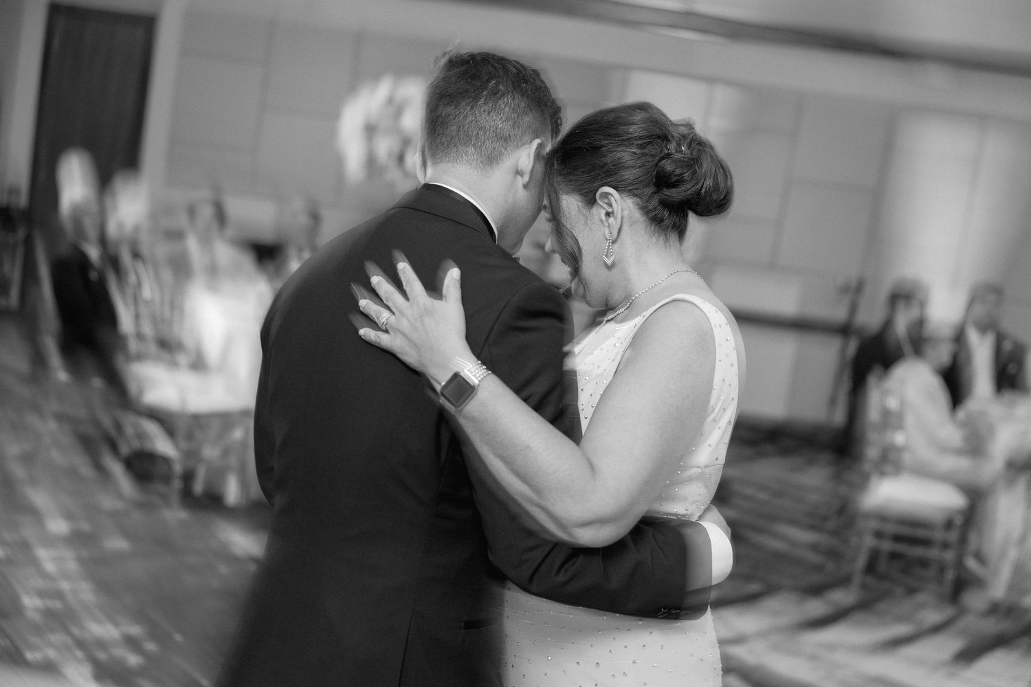 Black and white candid photo of a couple sharing an intimate dance moment.