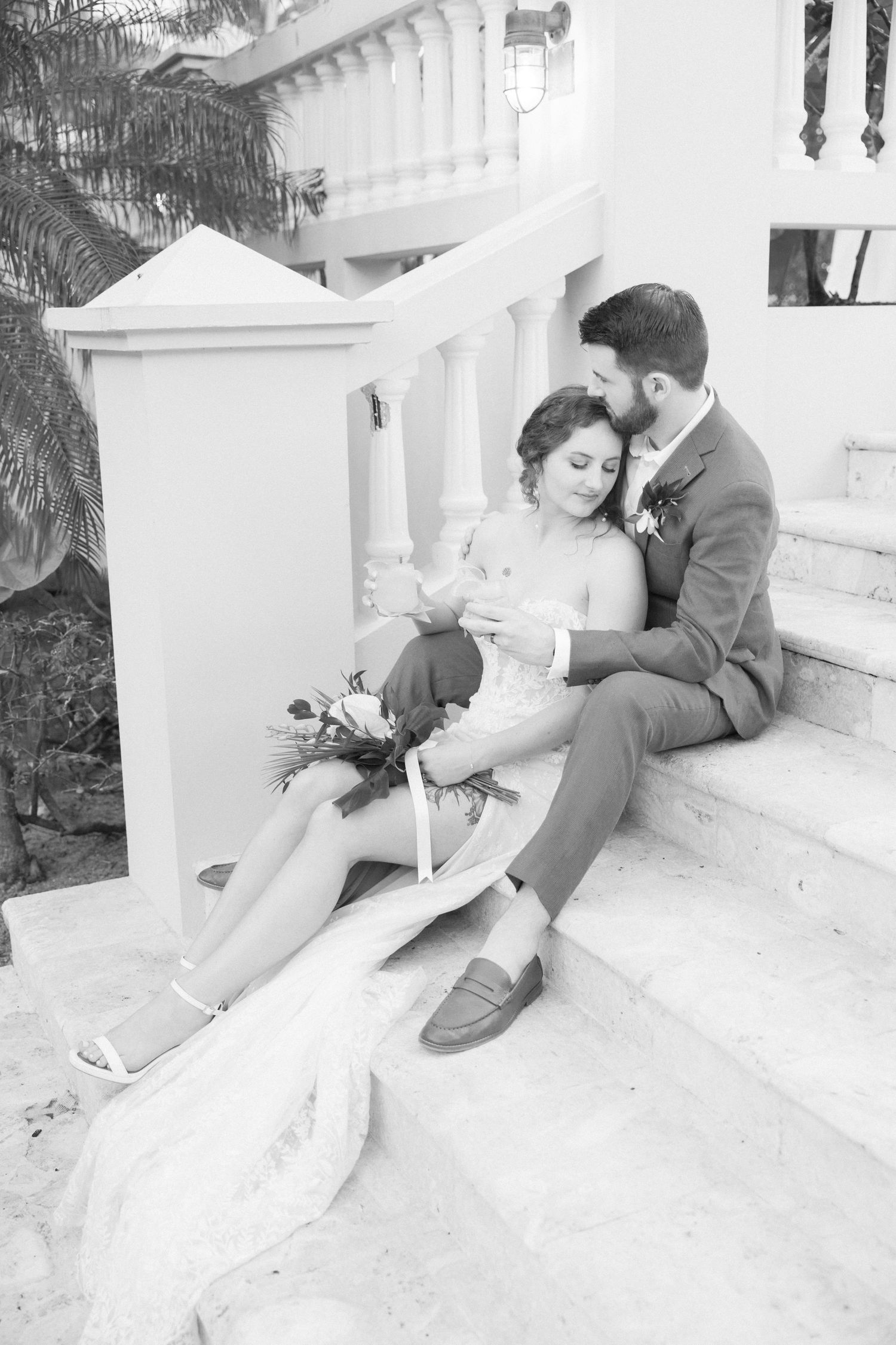 Artistic black and white wedding photos on white stairs capture romantic moments.