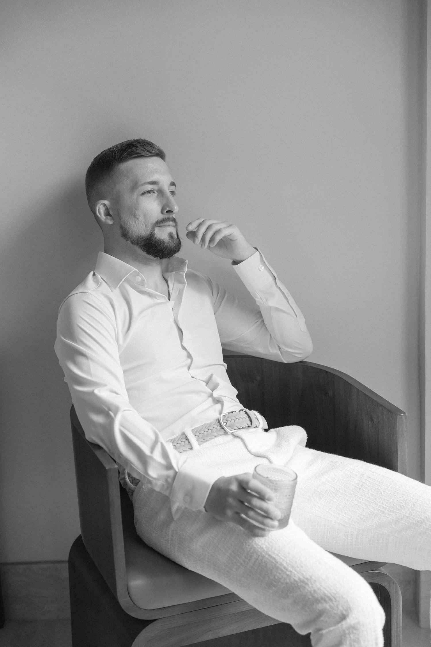 Artistic black and white portraits of a person relaxing in formal attire.
