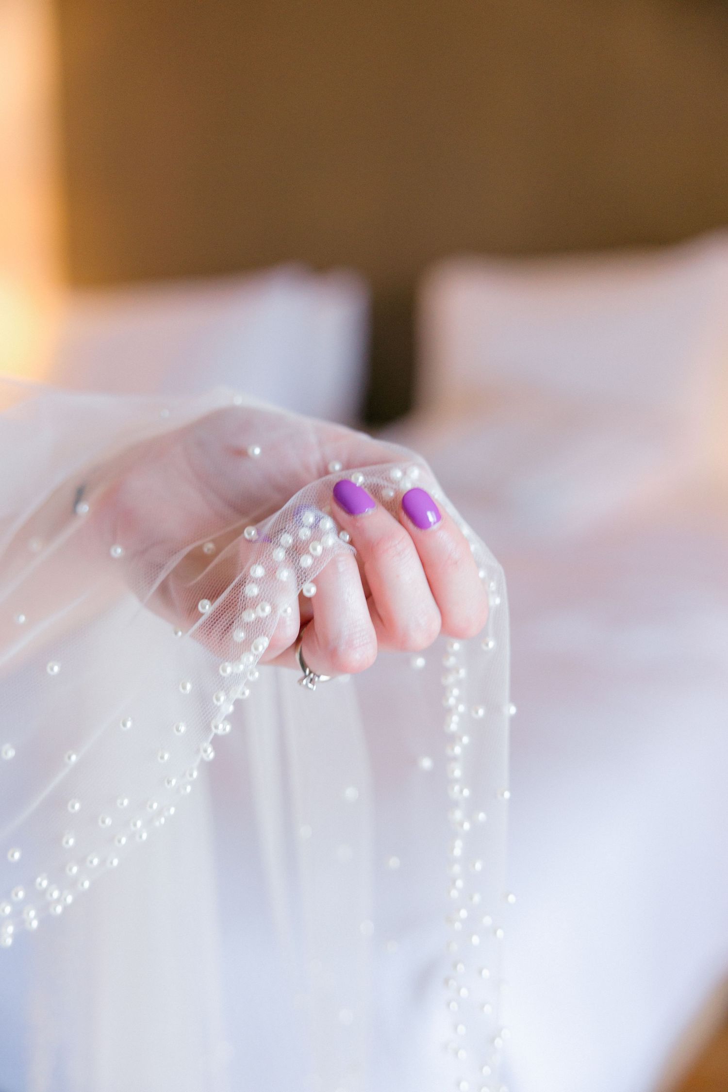 Delicate beaded veil details against soft white fabric.