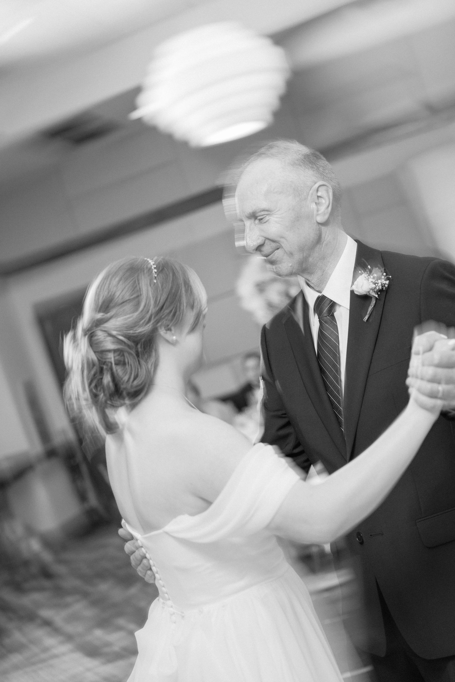 Black and white photo of a tender dance moment at an elegant wedding reception.