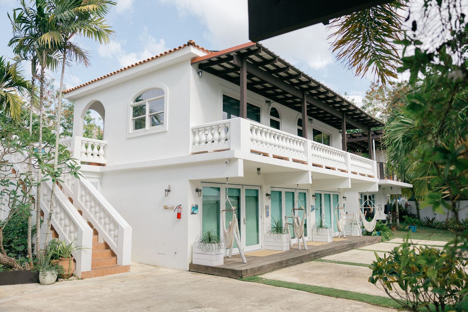 Mediterranean-style white villa with turquoise accents and palm trees for a destination wedding.