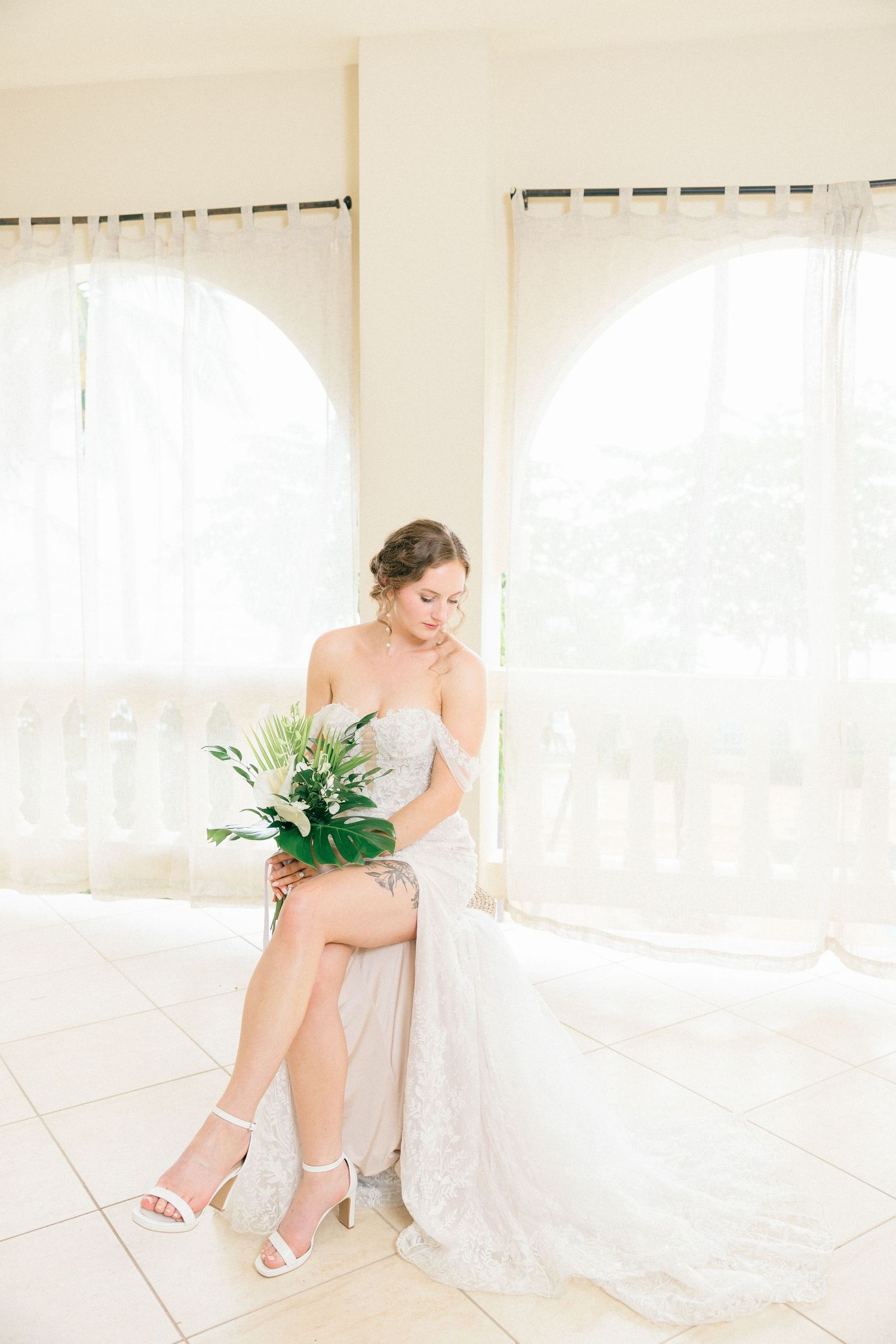 Elegant bridal preparation scene in a bright white room with natural light.
