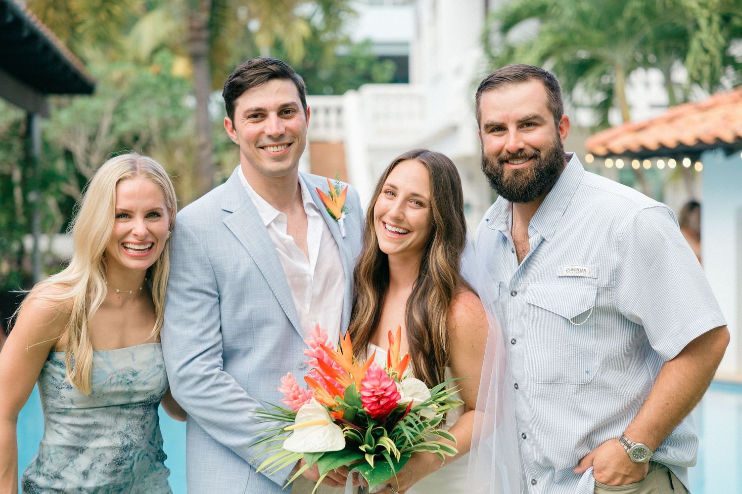 Candid wedding party photos taken outdoors at a tropical venue with Spanish-style architecture.