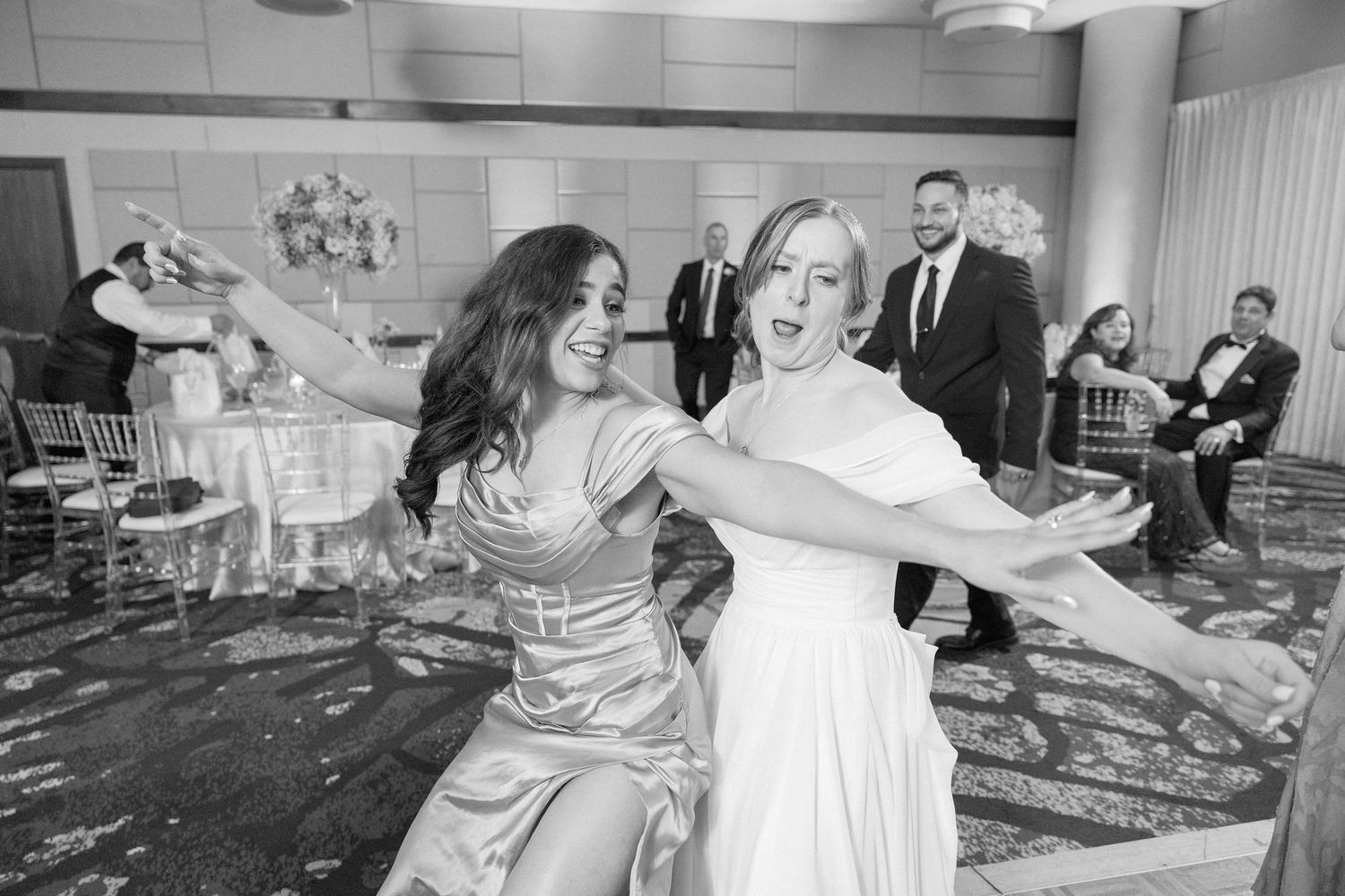 Wedding guests performing a synchronized dance move during a reception celebration.