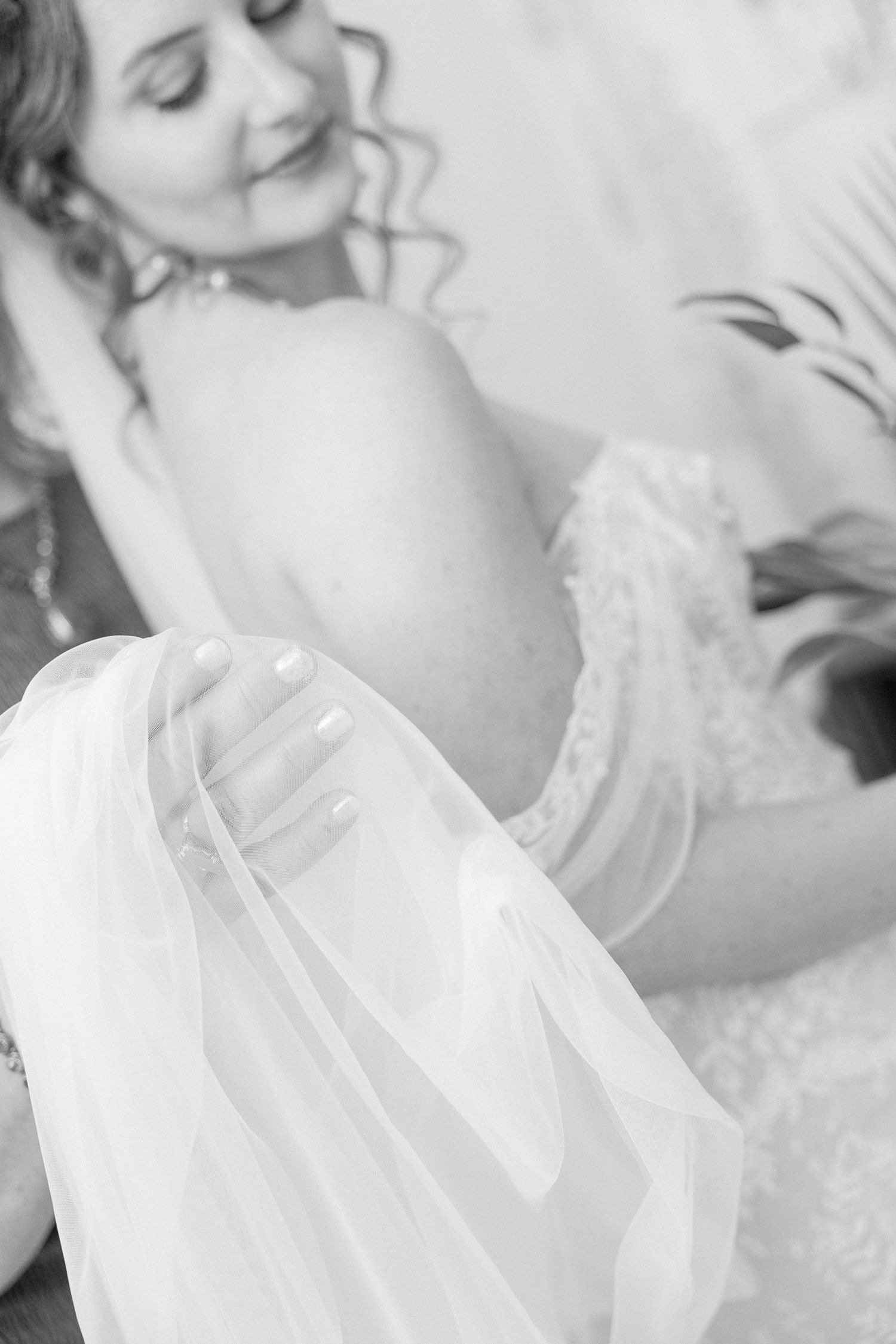 Close-up details of delicate white lace and tulle fabric from a wedding dress.
