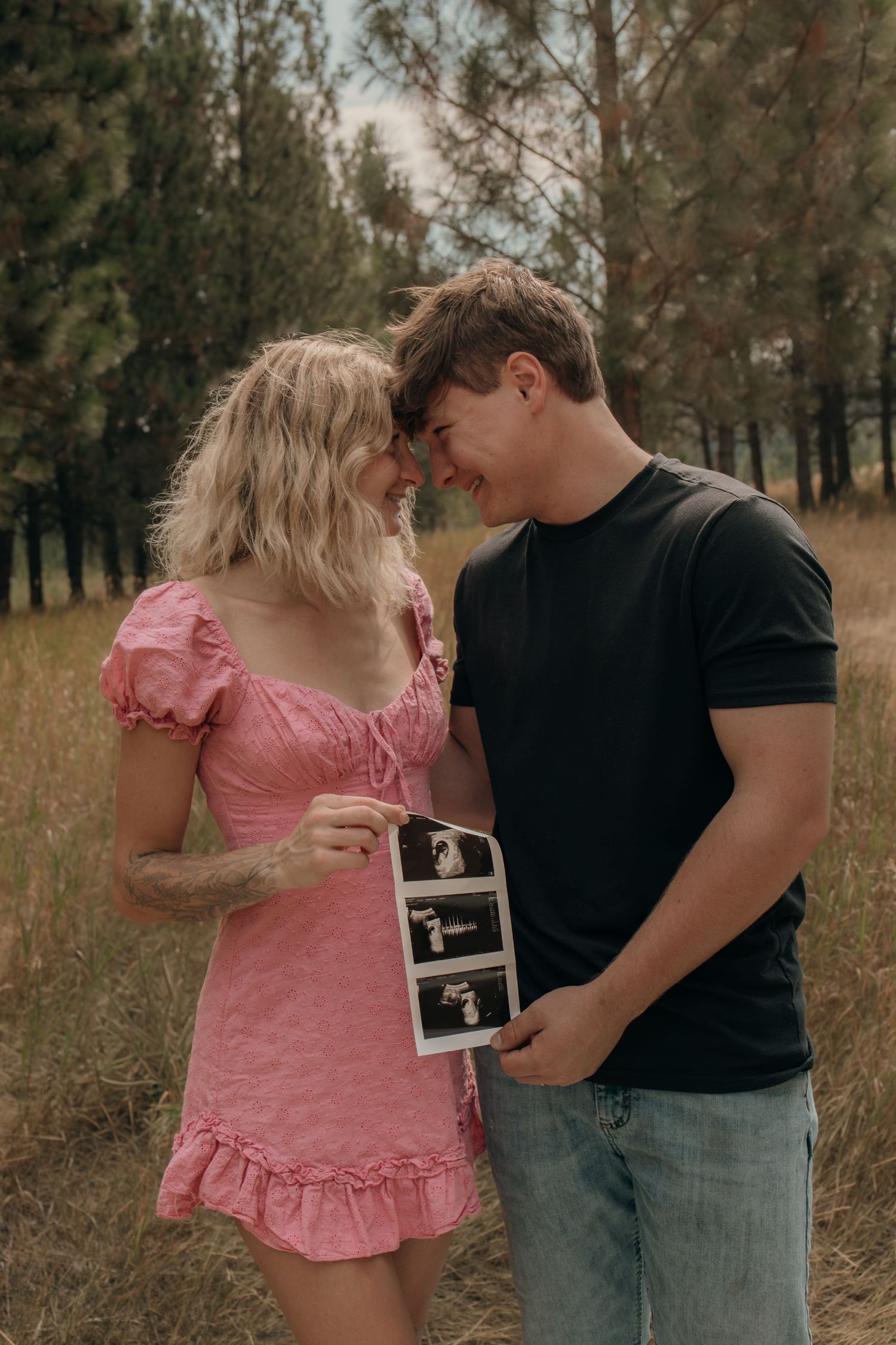 Couple holding ultrasound picture during photoshoot, Rain & Reverie photography
