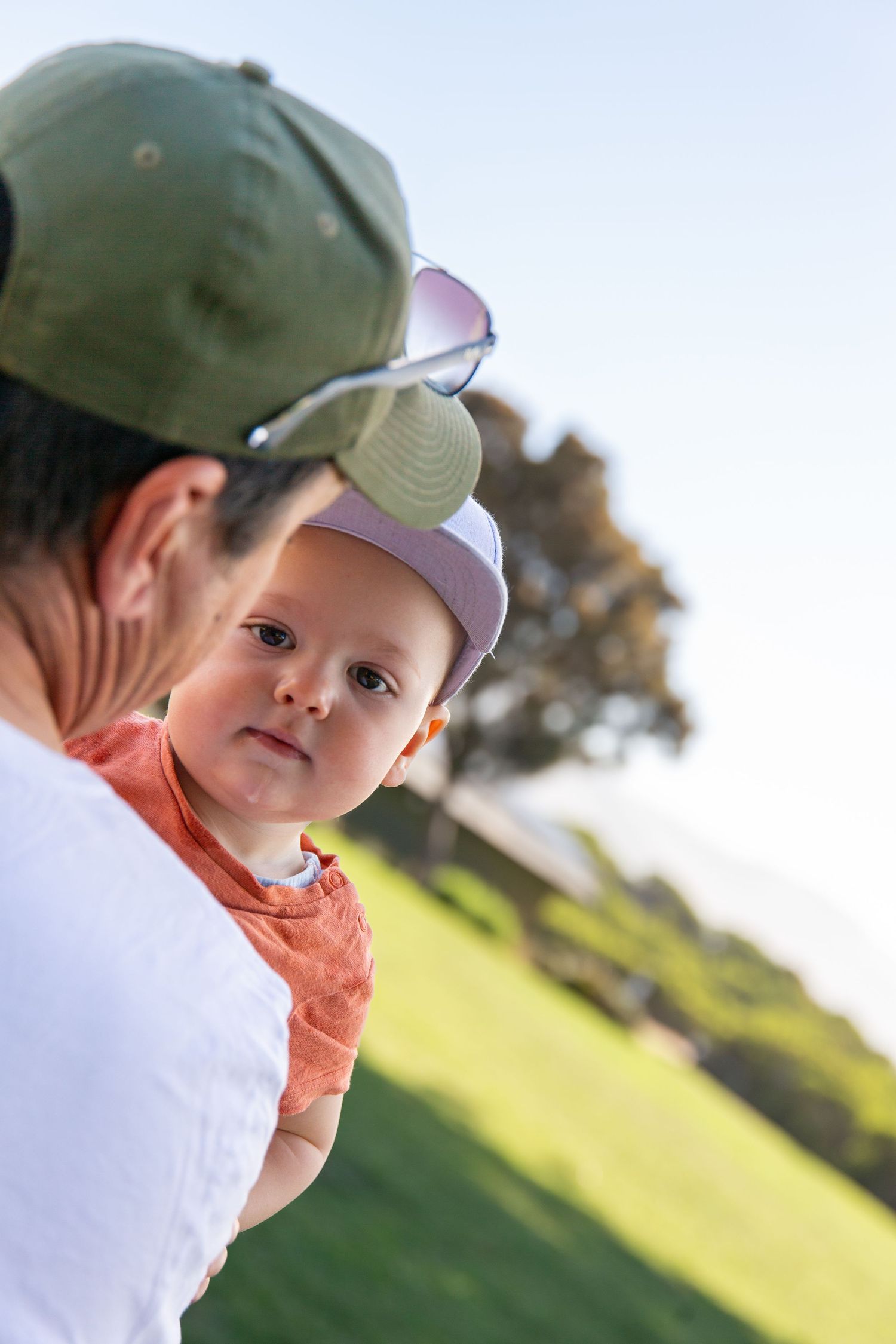 Close-up of a young child wearing baseball cap in outdoor setting.