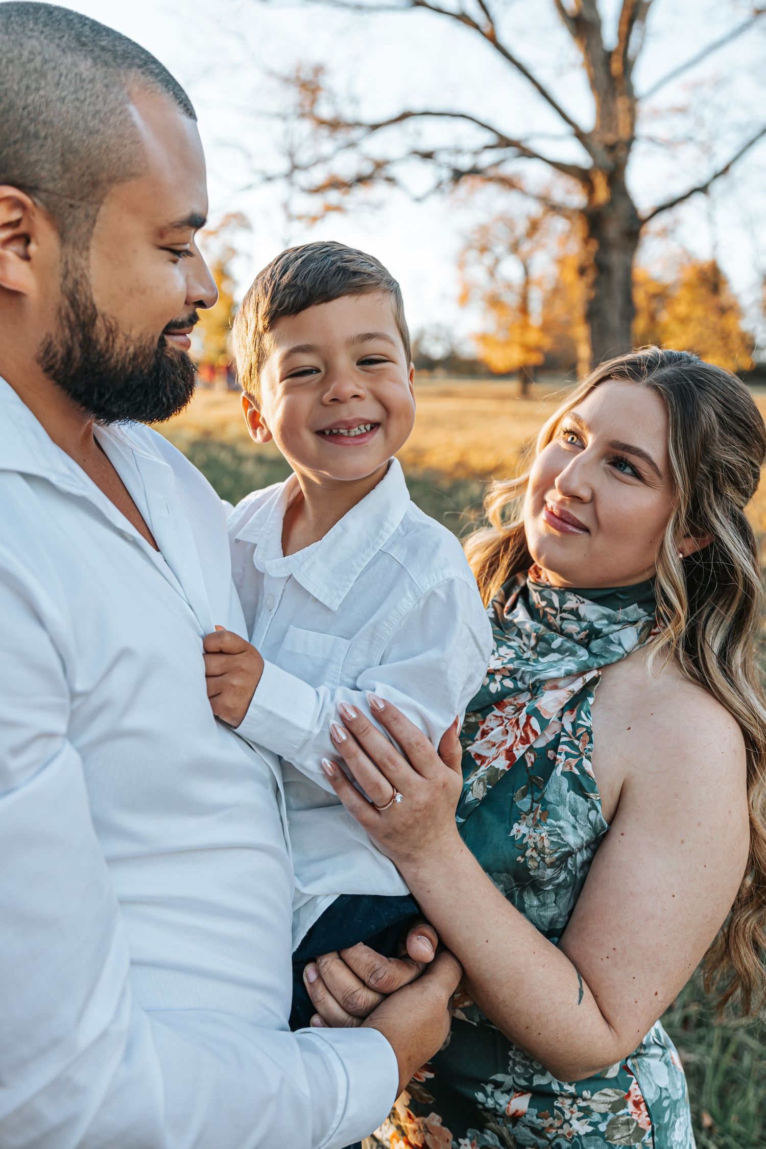 A joyful outdoor family photo session capturing playful moments in warm sunlight.