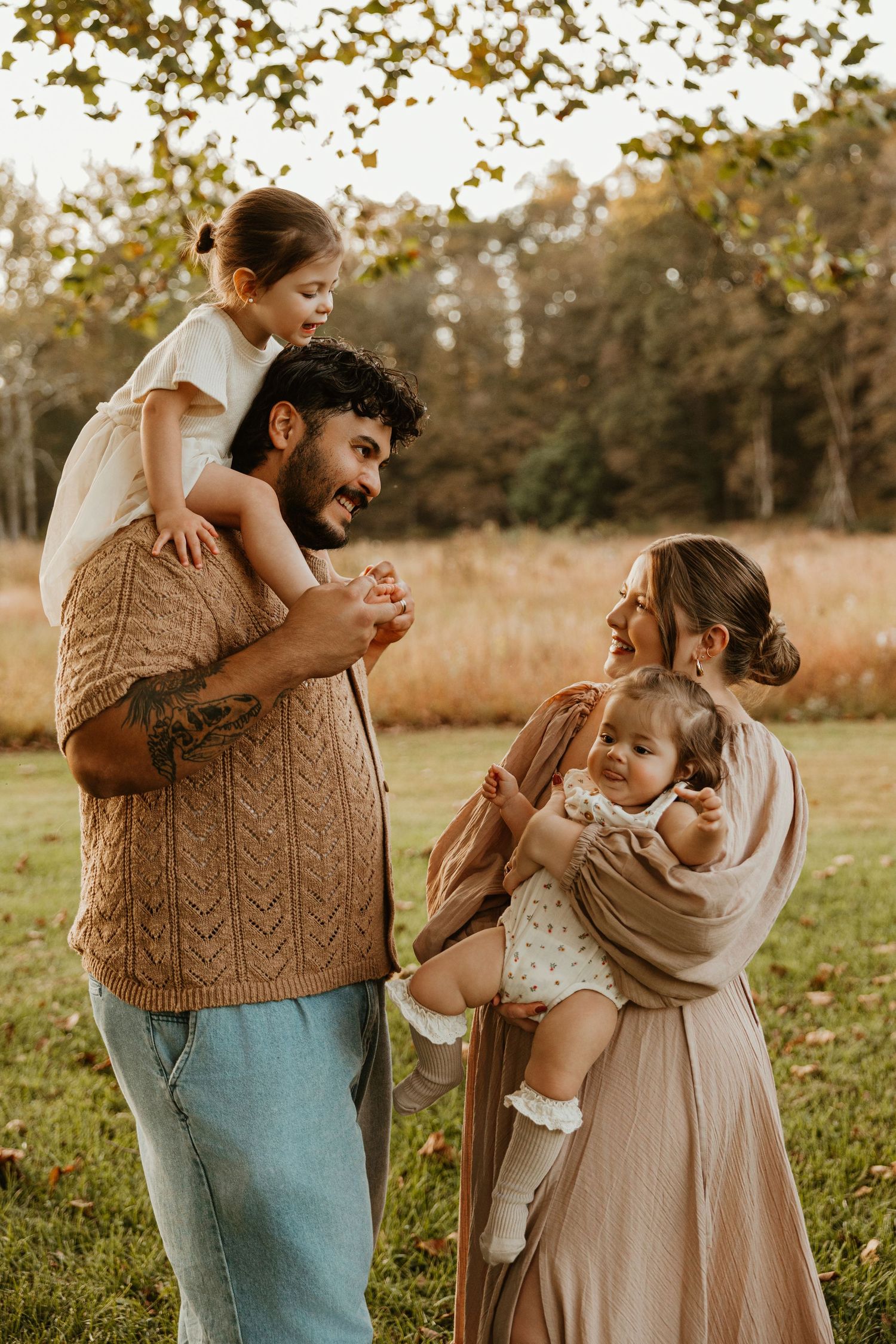 Candid family moments captured in warm autumn light wearing coordinated neutral tones.