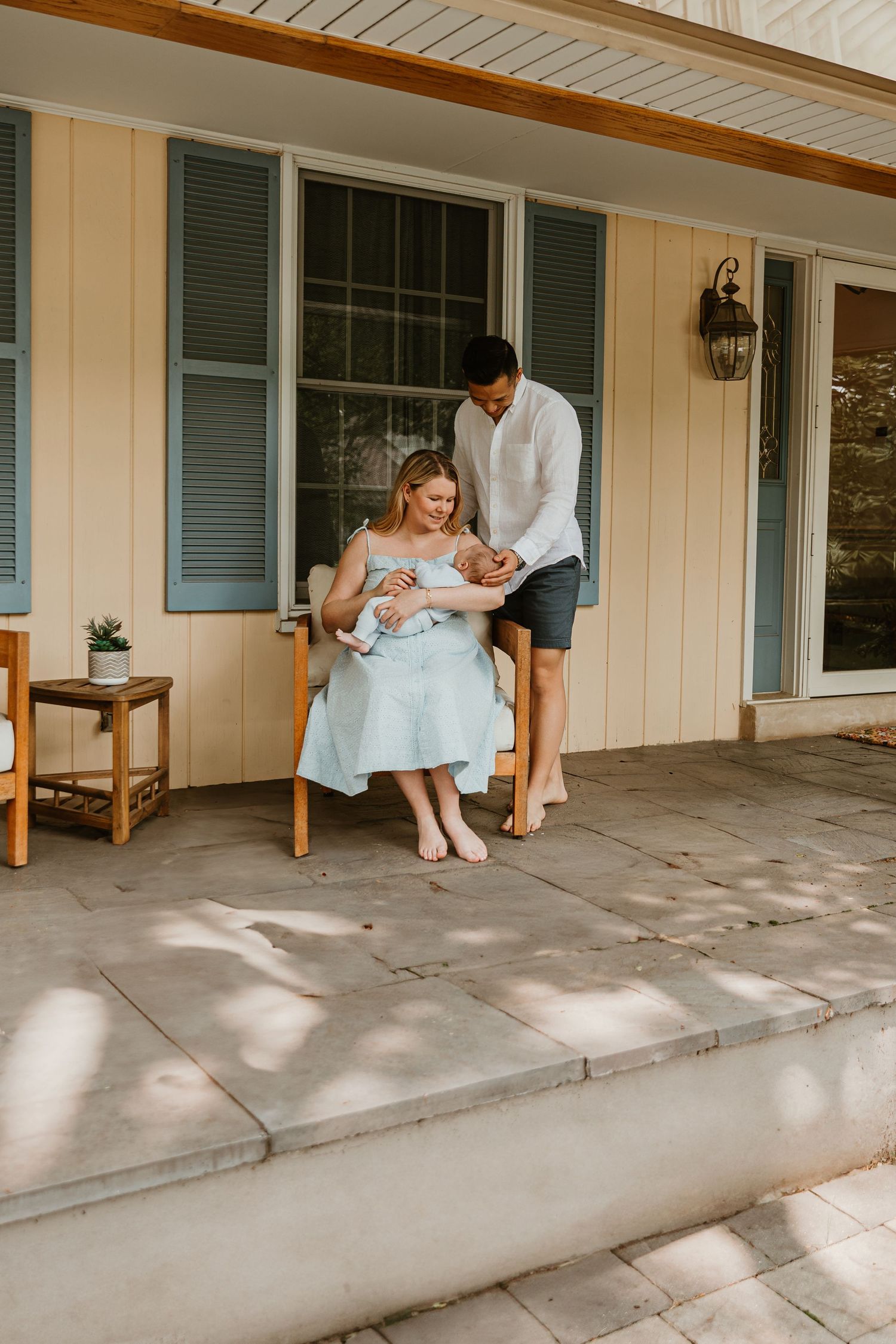 Family sitting together on covered porch in soft natural light.