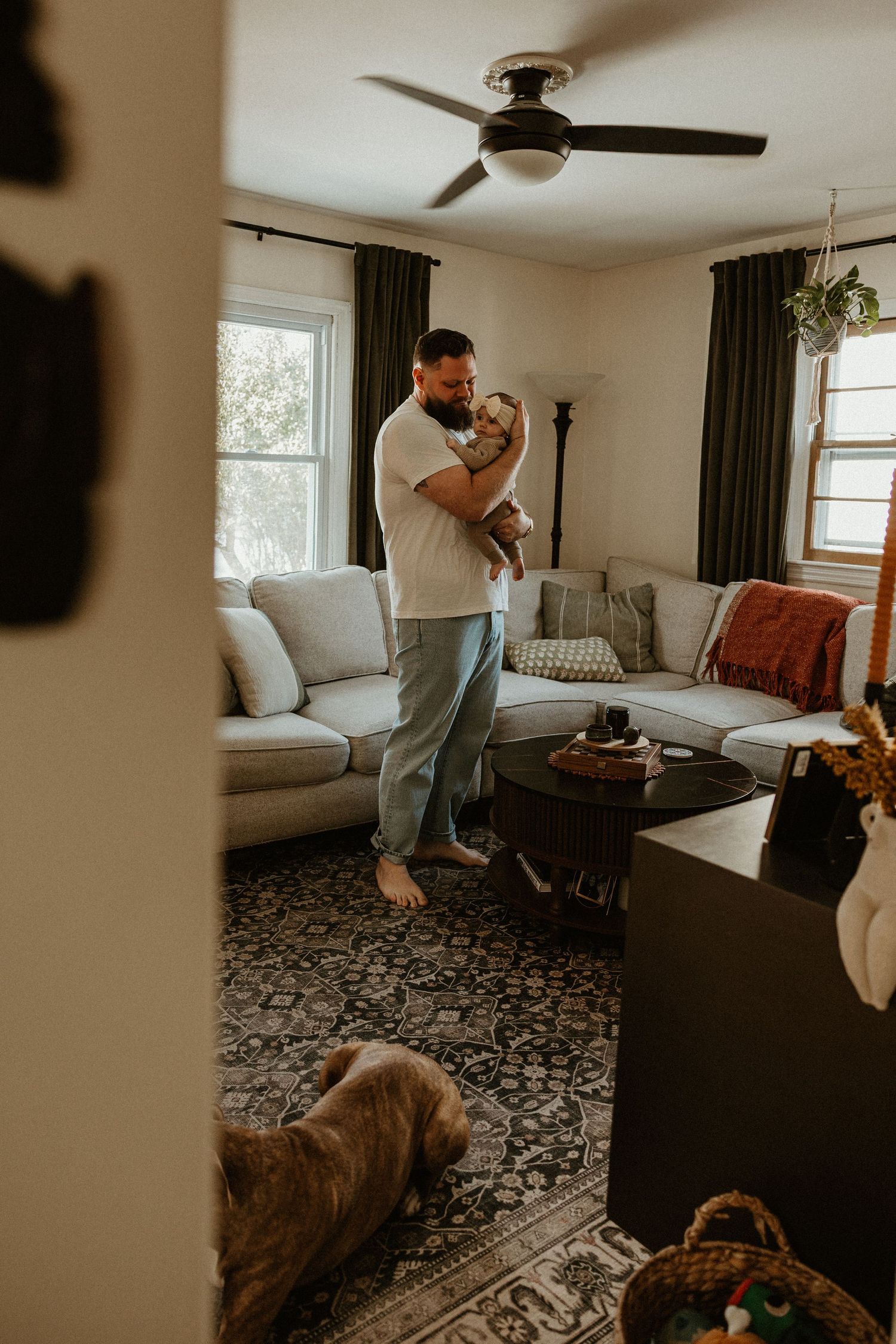 Candid family moments captured in a living room with a patterned rug and ceiling fan.