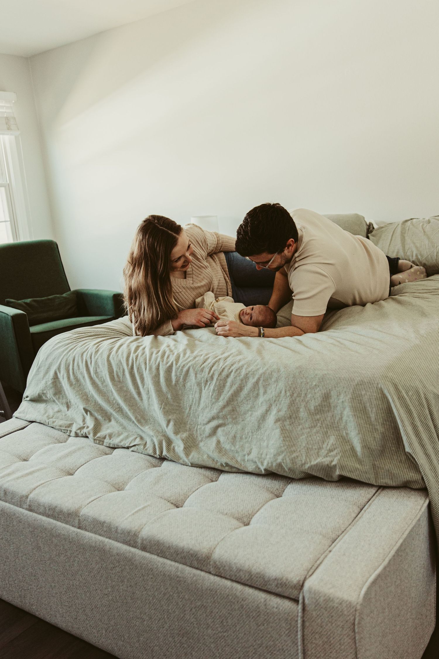 Family sharing intimate moment together on gray bed.