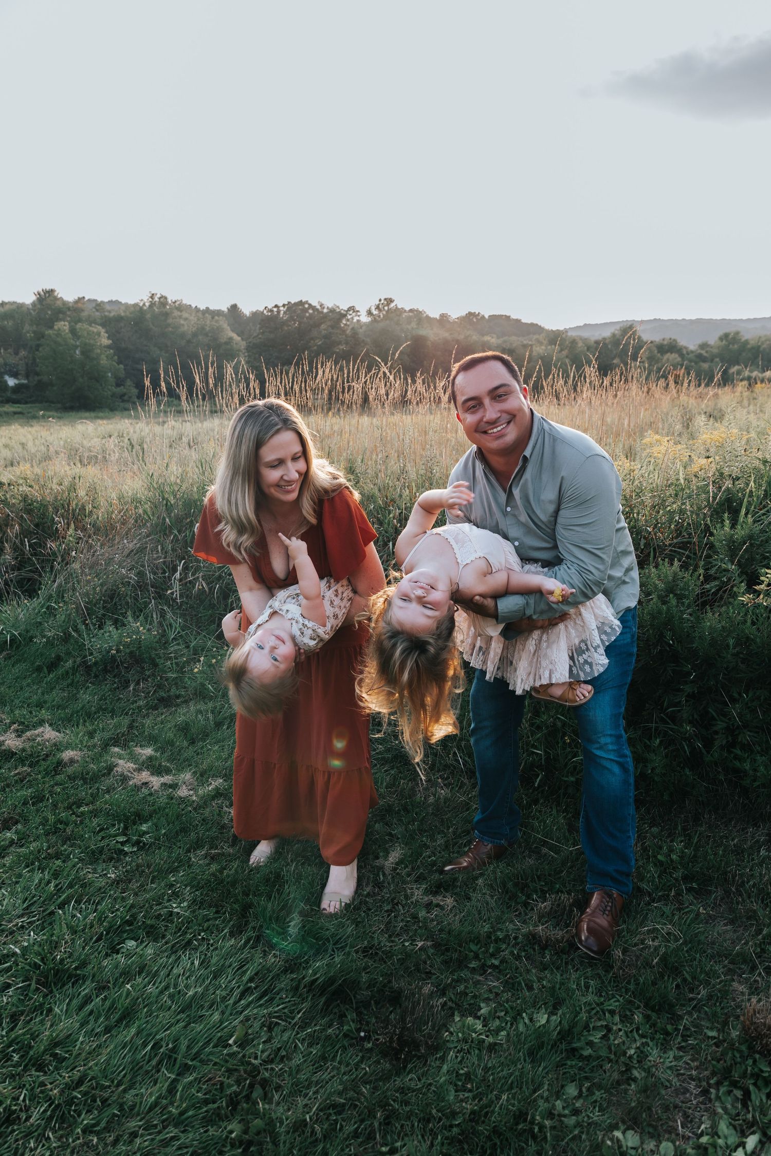 Family sharing joyful moments together in a meadow at dusk.