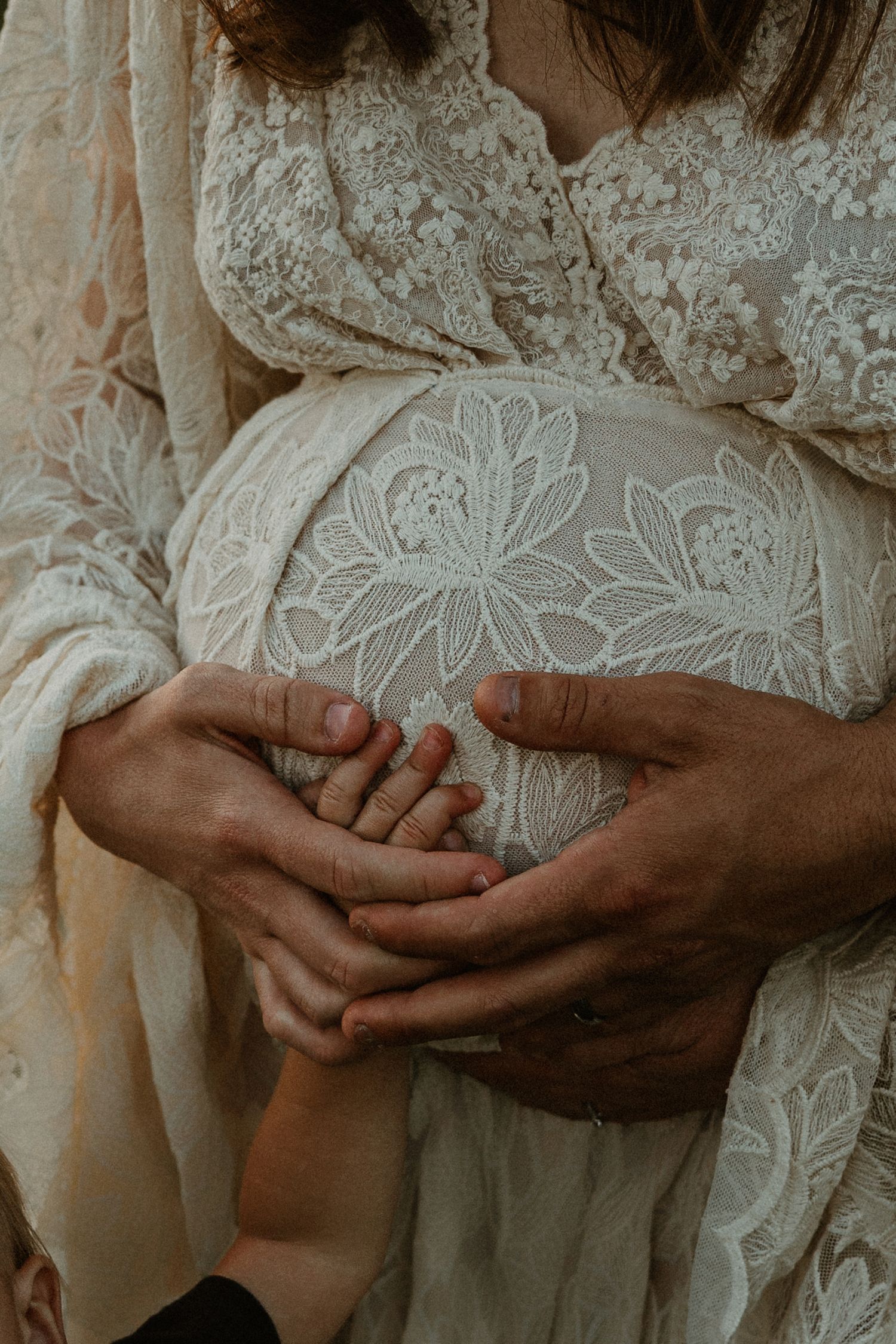 Delicate close-up of hands against intricate white lace fabric details.