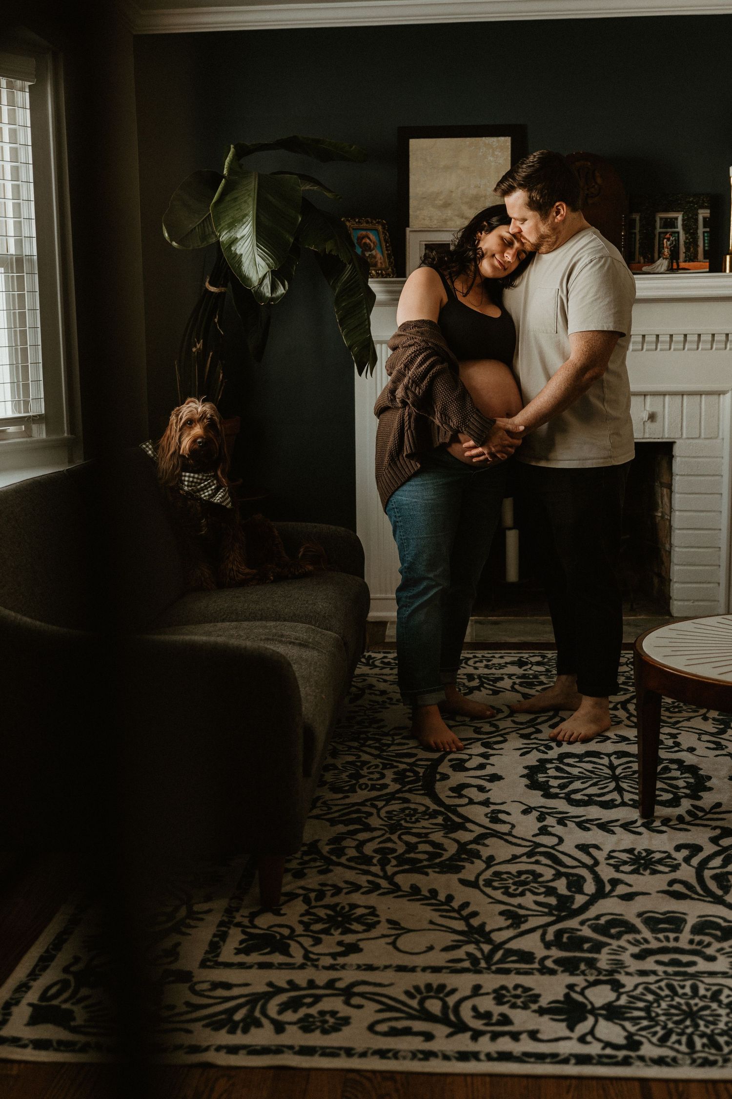 Intimate couple's photography session on patterned floor in moody lighting.