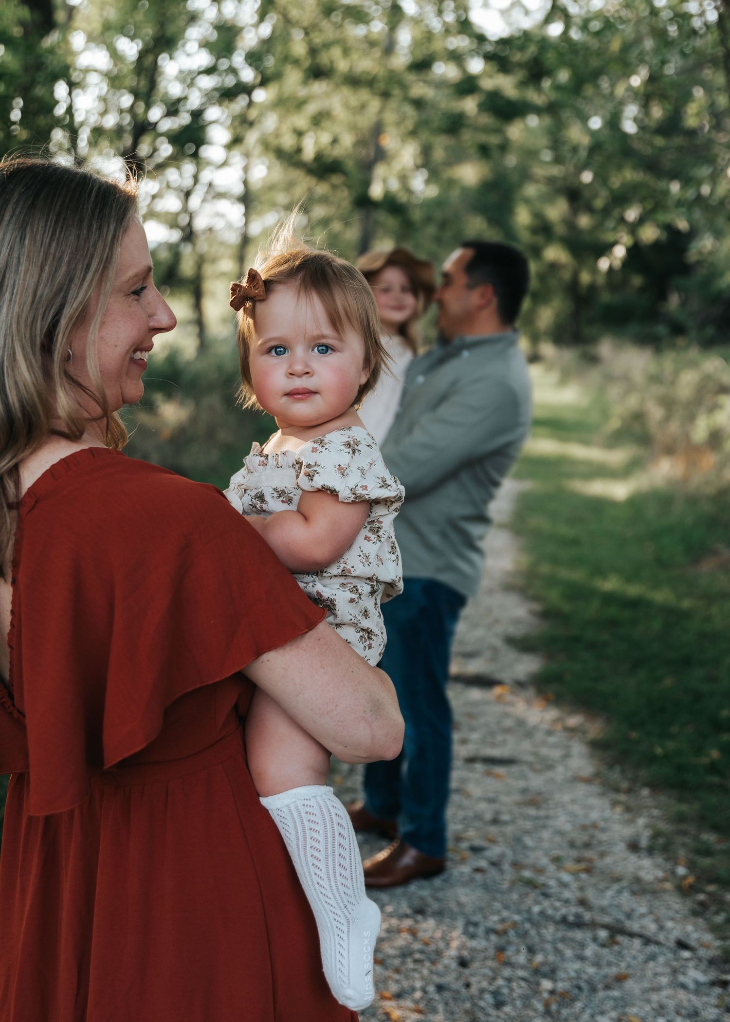 Sweet candid moments captured on a wooded path during sunset.