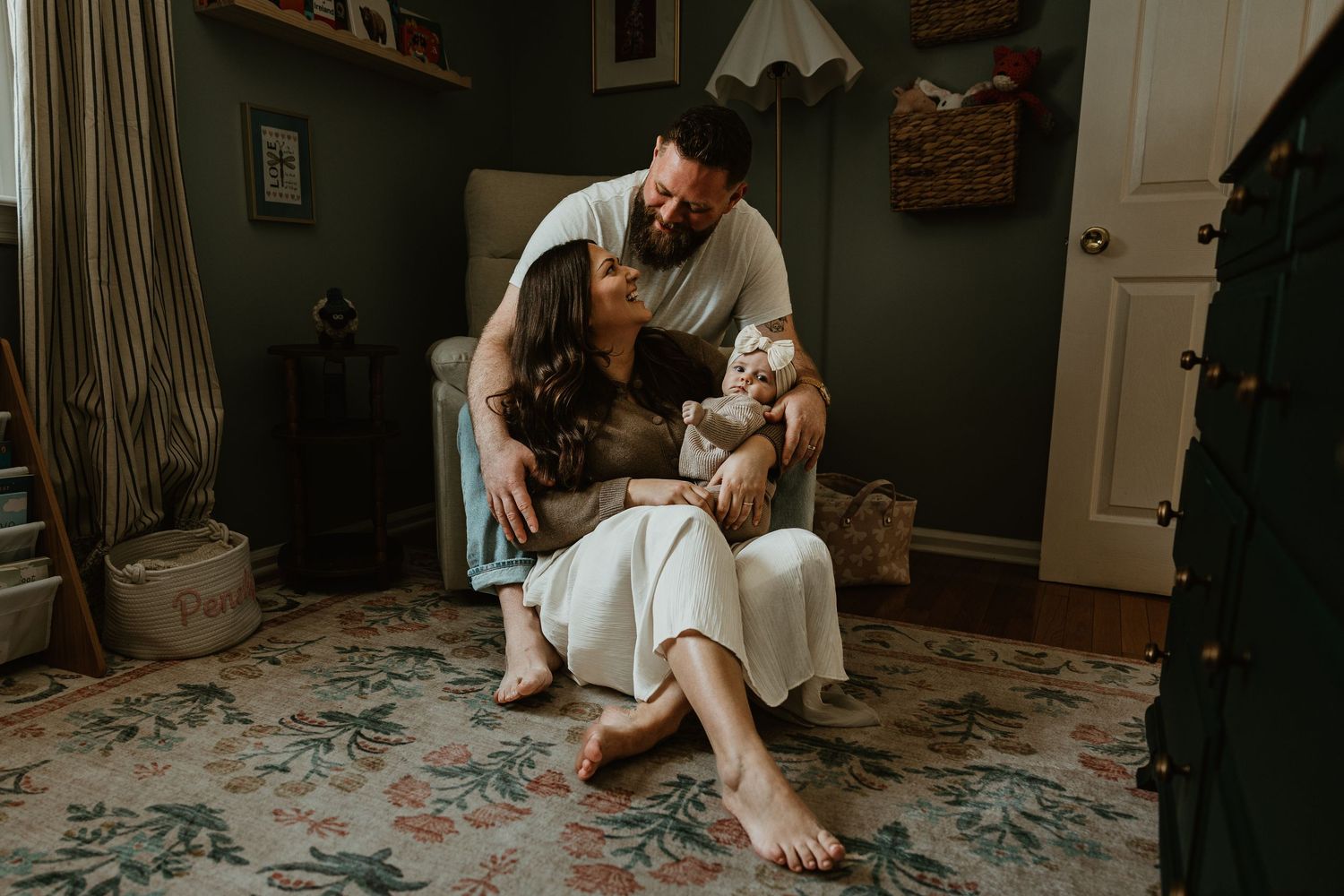 A cozy family lifestyle photoshoot in a home living room with natural lighting and a floral rug.