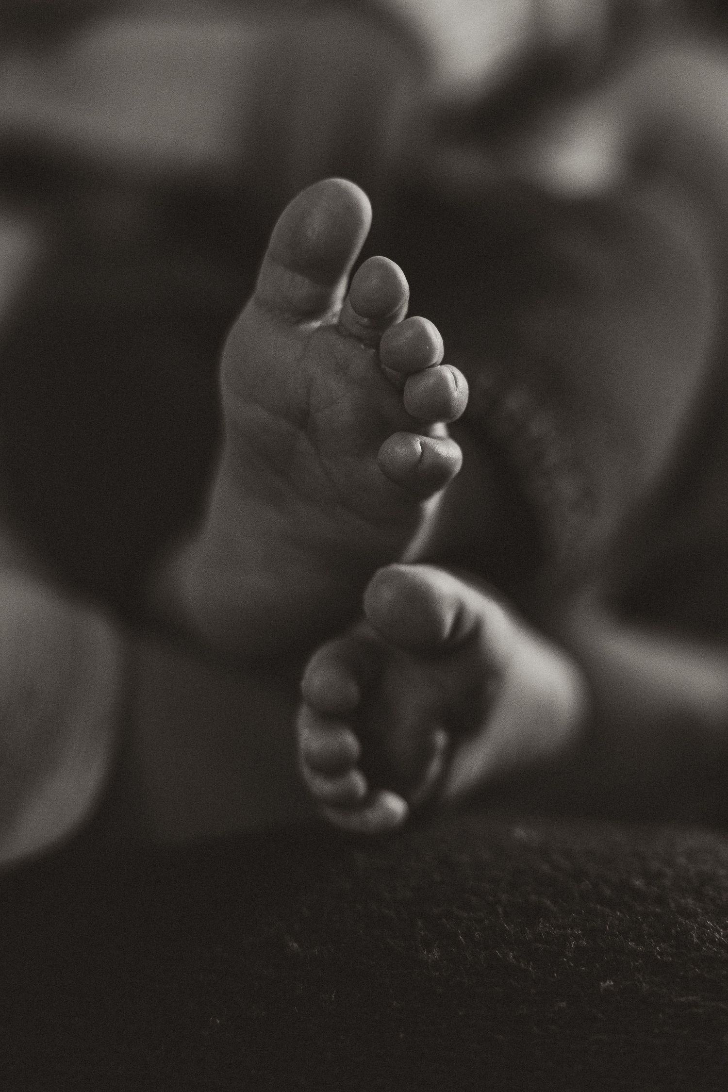 Artistic black and white close-up of baby toes and feet.