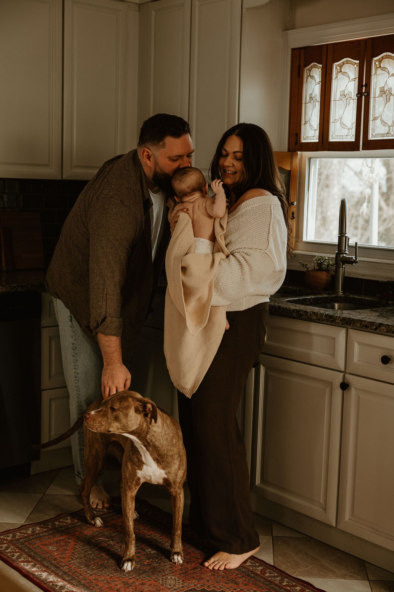 Lifestyle family photos in a kitchen with white cabinets and a pet dog.