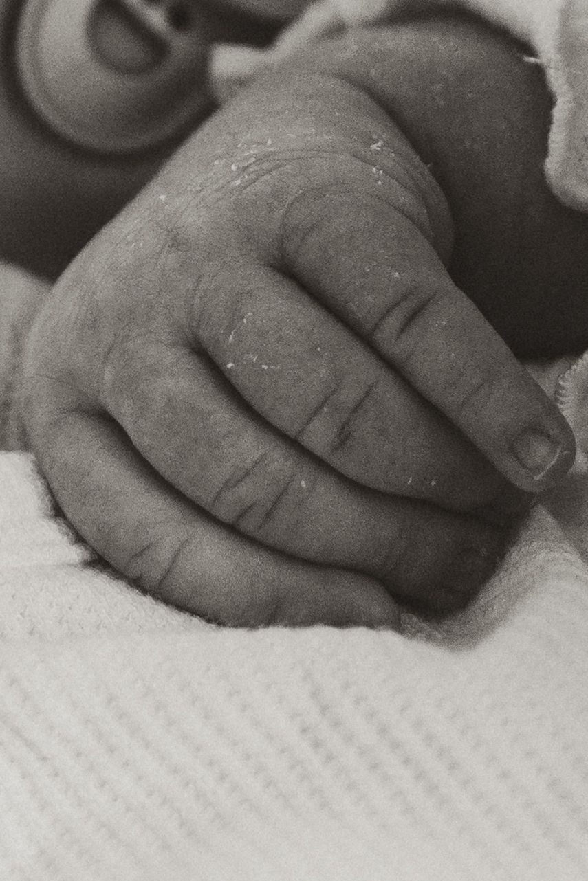 Close-up black and white sequence showing fingers gently touching a textured surface.
