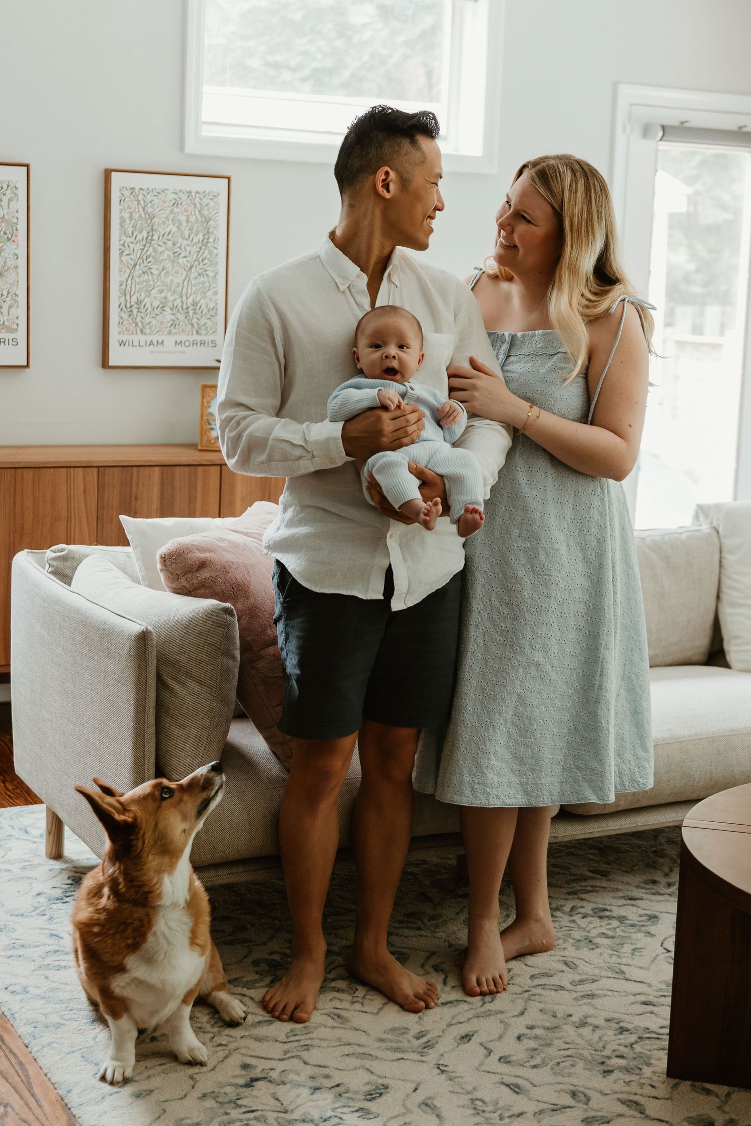 Family and corgi dog sharing casual moments in bright living room.
