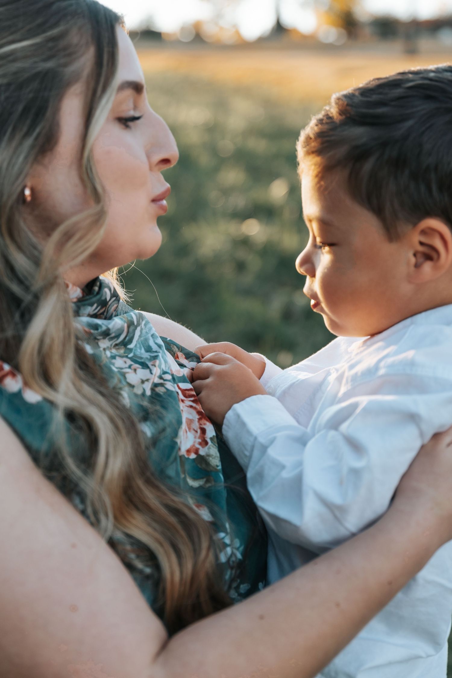 Candid family portraits showing tender moments between parent and child in natural lighting.