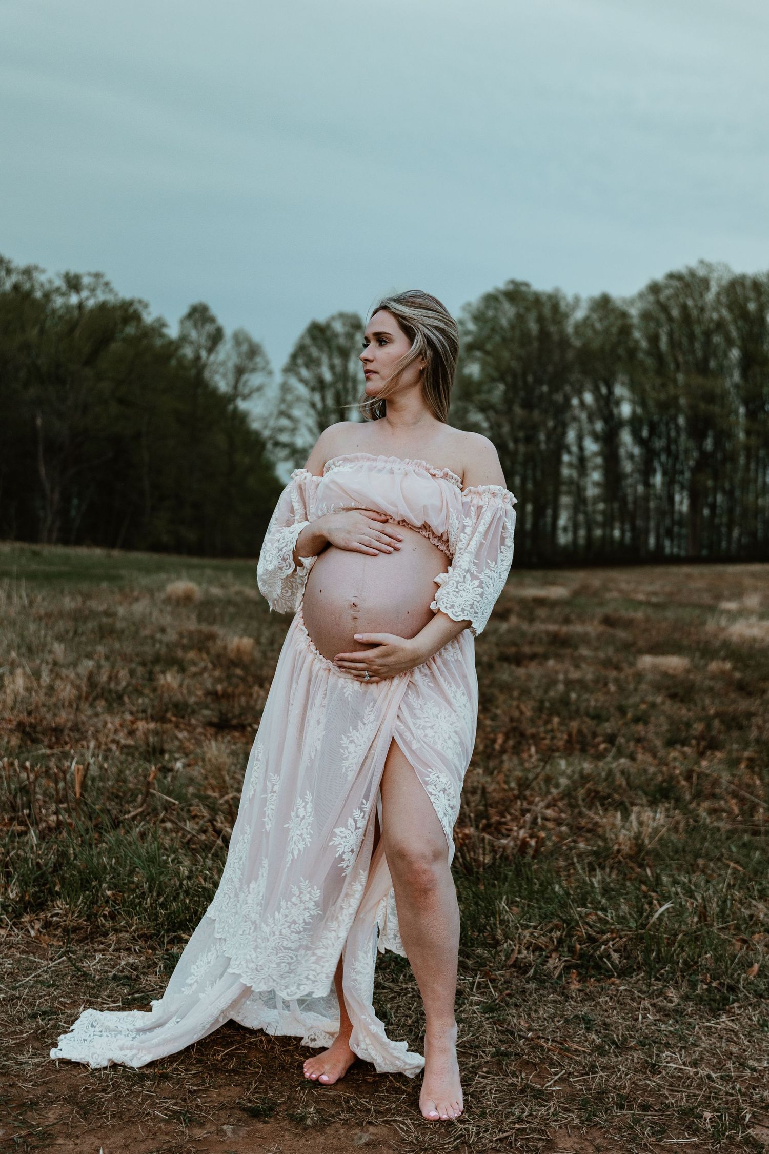 A romantic maternity photo session in a field during golden hour.
