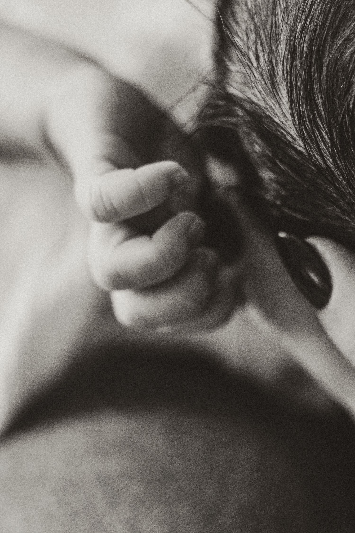 Artistic black and white close-up of an ear and hair detail.