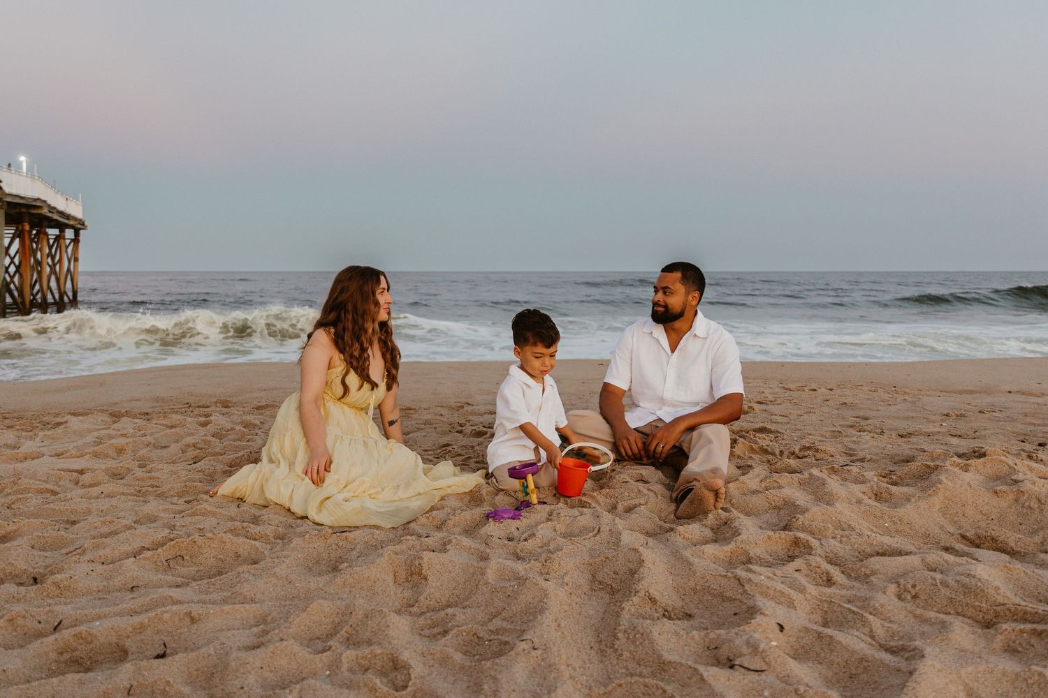 A family enjoying quality time together on the beach during golden hour.