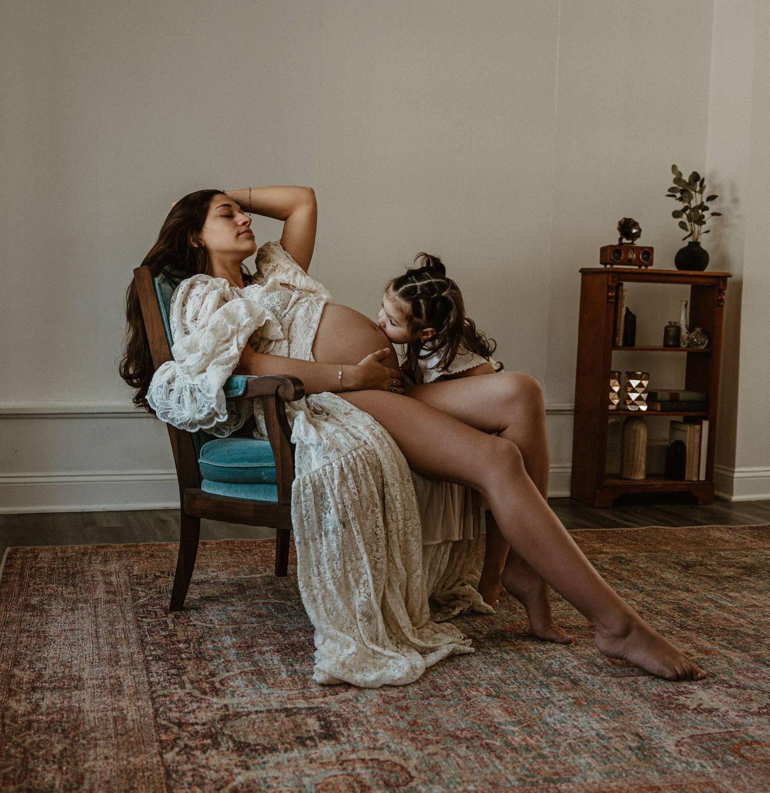Artistic portrait session on vintage carpet with antique furniture and moody lighting.