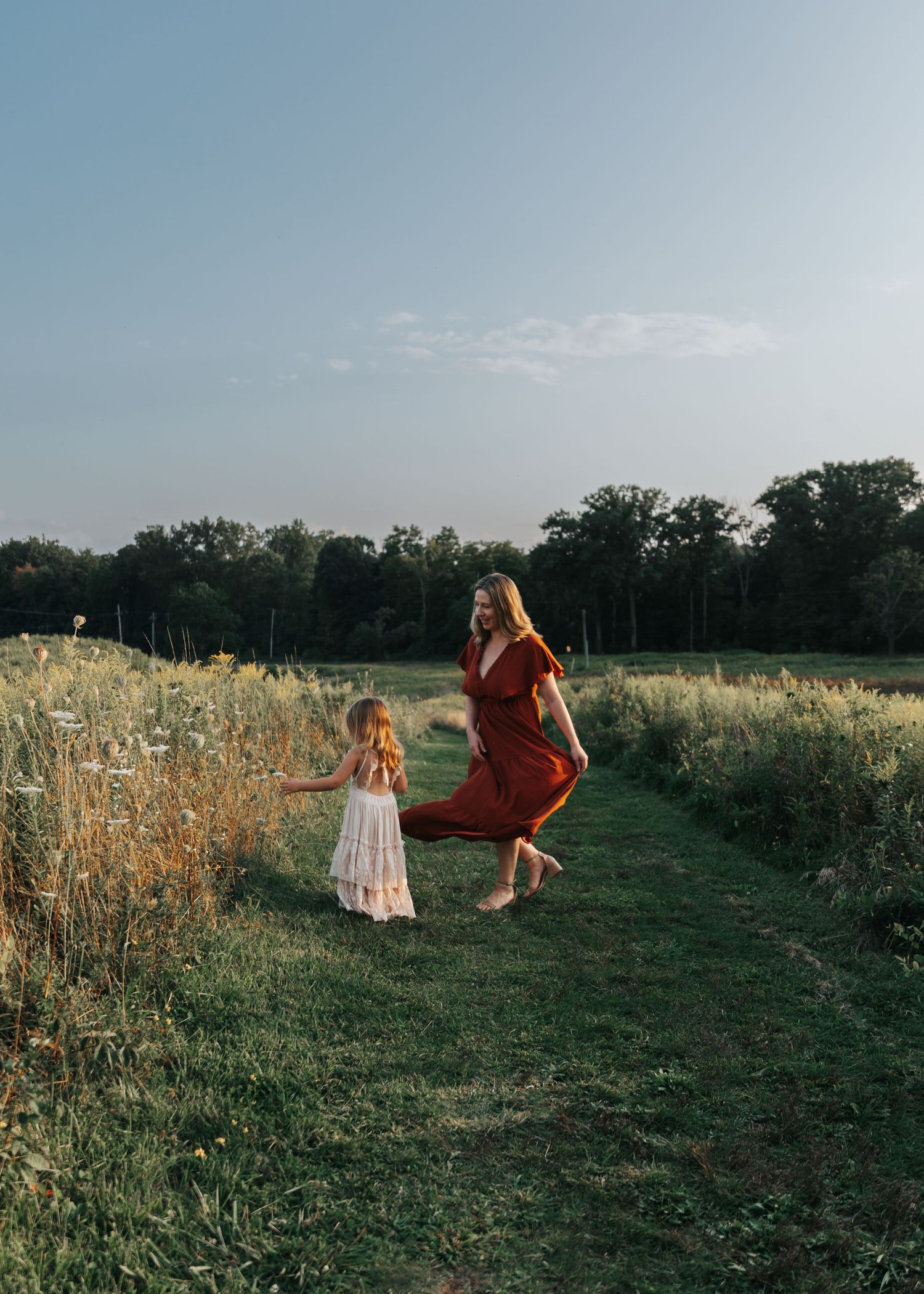 People playing and running through a scenic field at sunset.