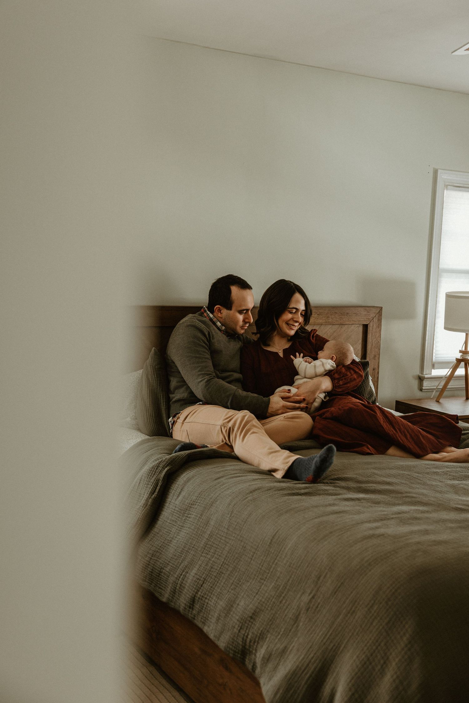 Intimate moment shared on gray bedding in minimalist bedroom setting.