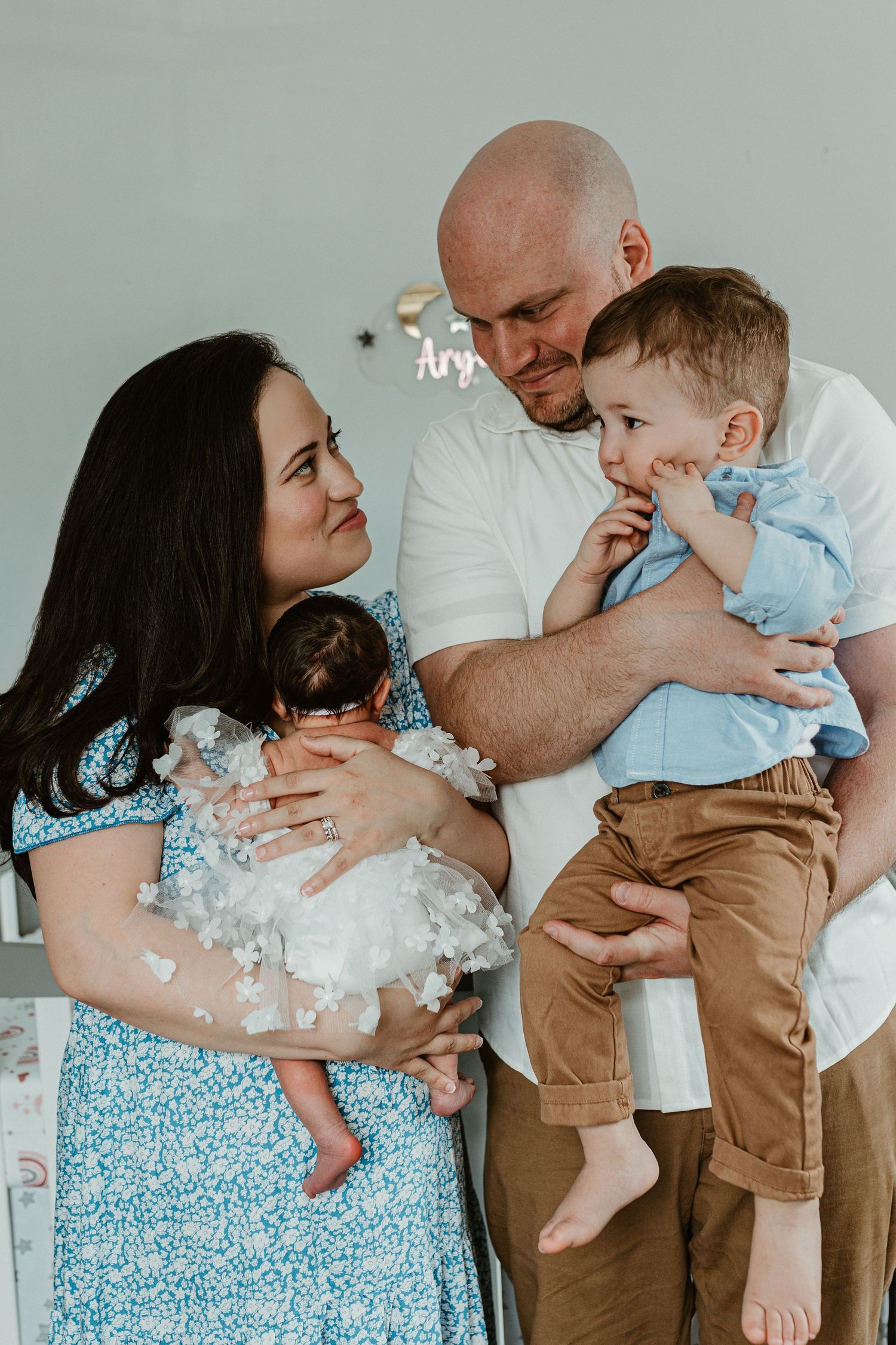 A family shares playful moments together while wearing coordinated blue and white outfits.