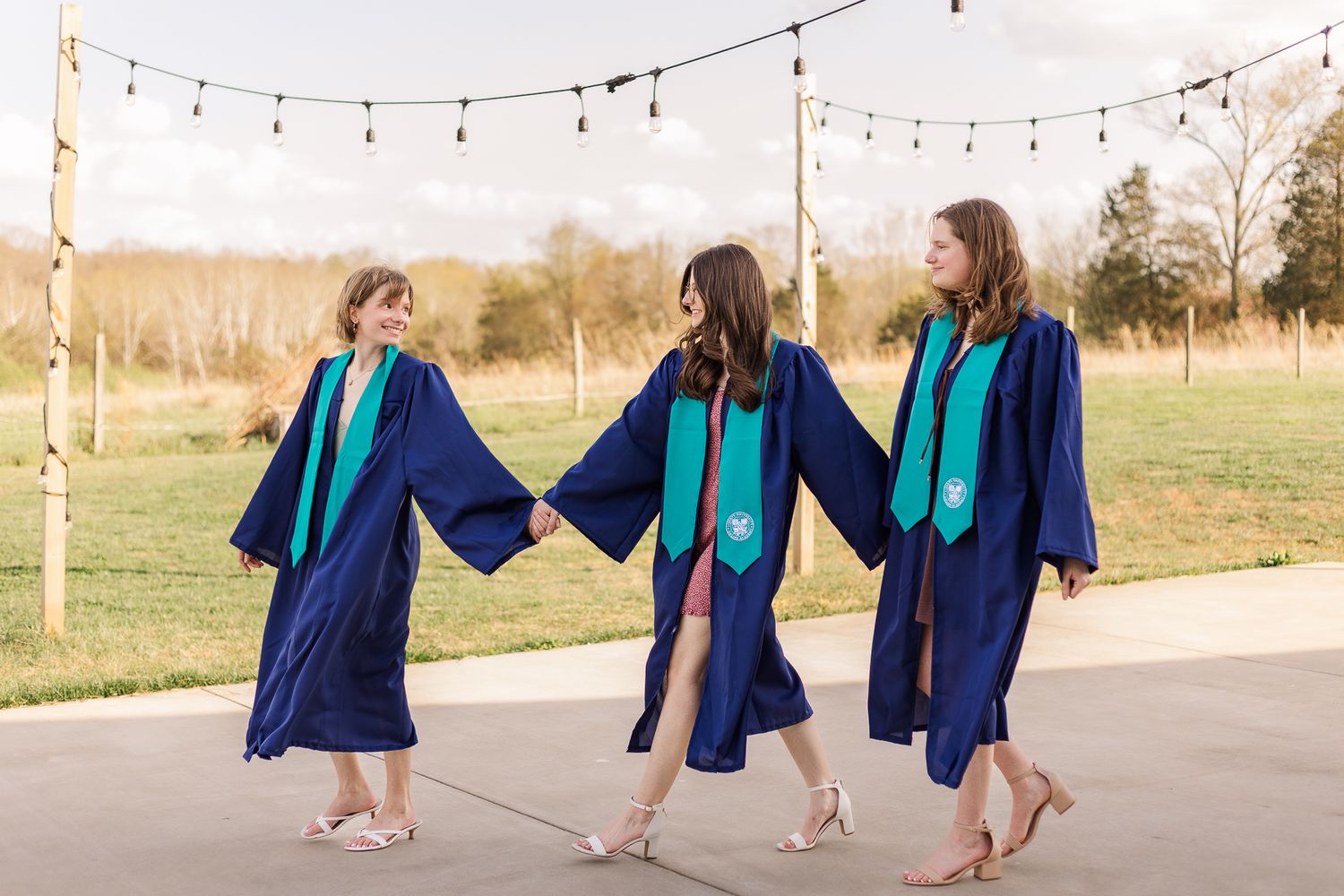 A group of young girls smiling and holding hands during a graduation photoshoot in nokesville virginia