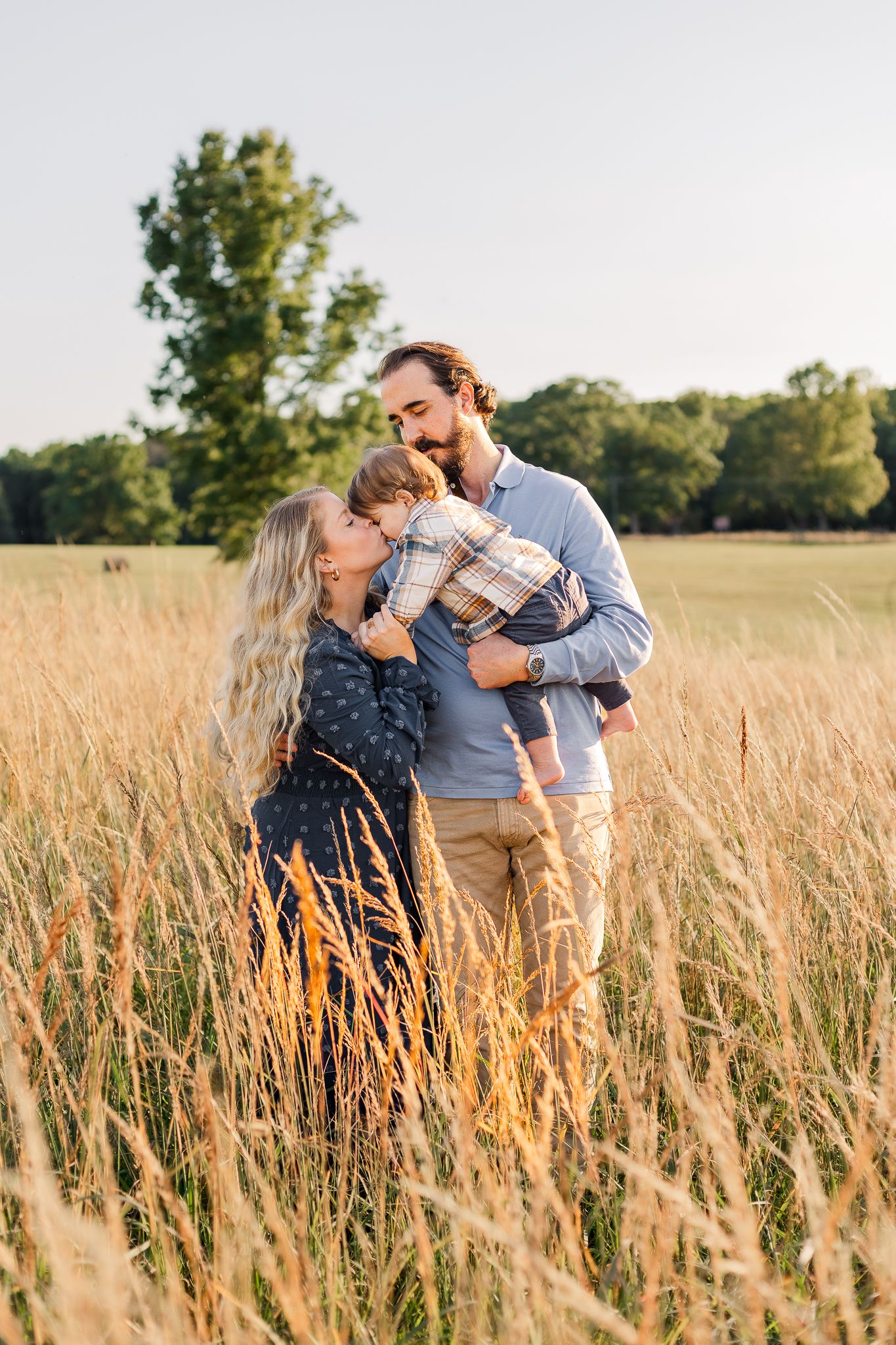 a young family smiling together during fall at manassas battlefield