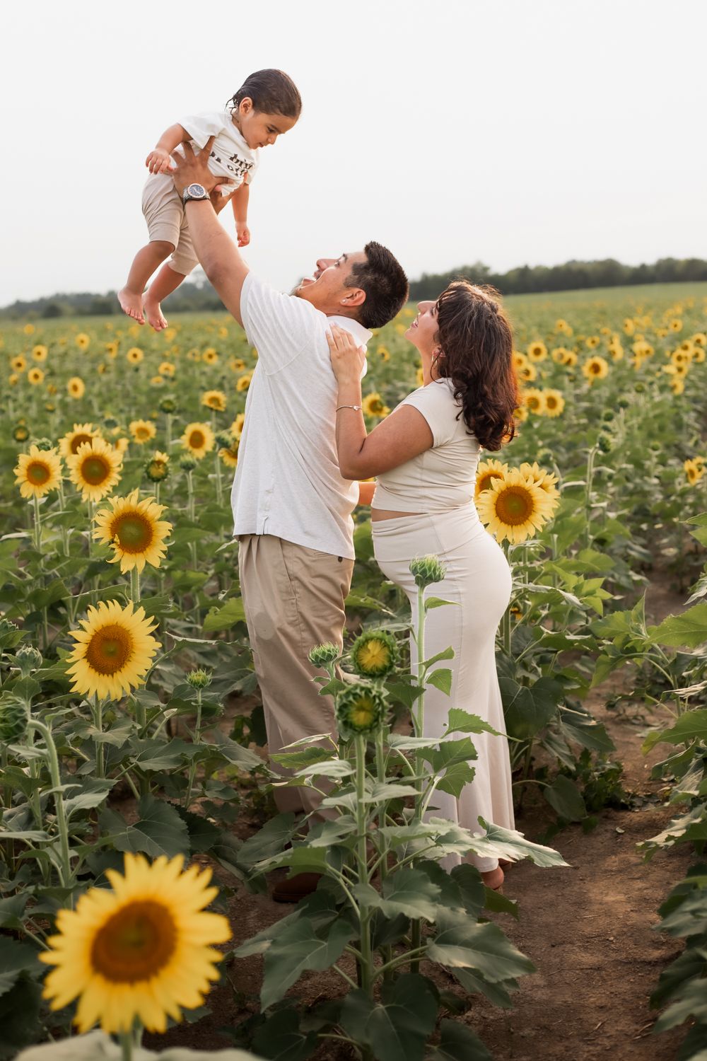 a young couple smiling at the sunflower fields of burnside farms nokesville virginia