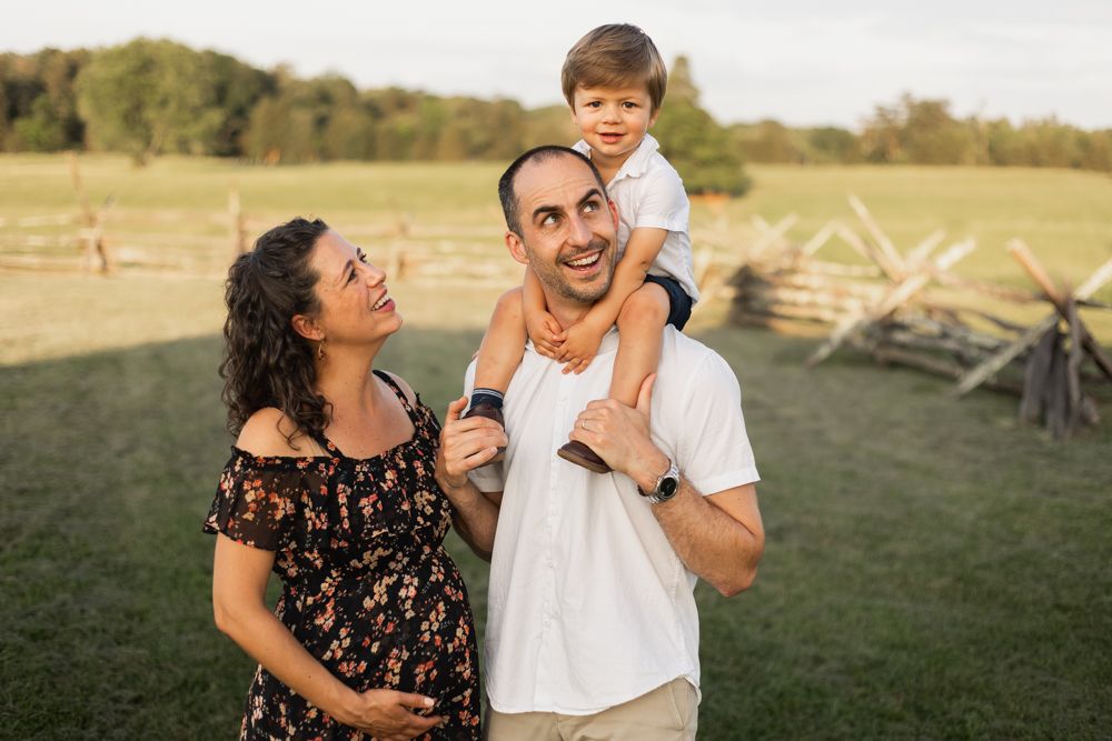 A young family smiling during sunset at manassas battlefield, virginia