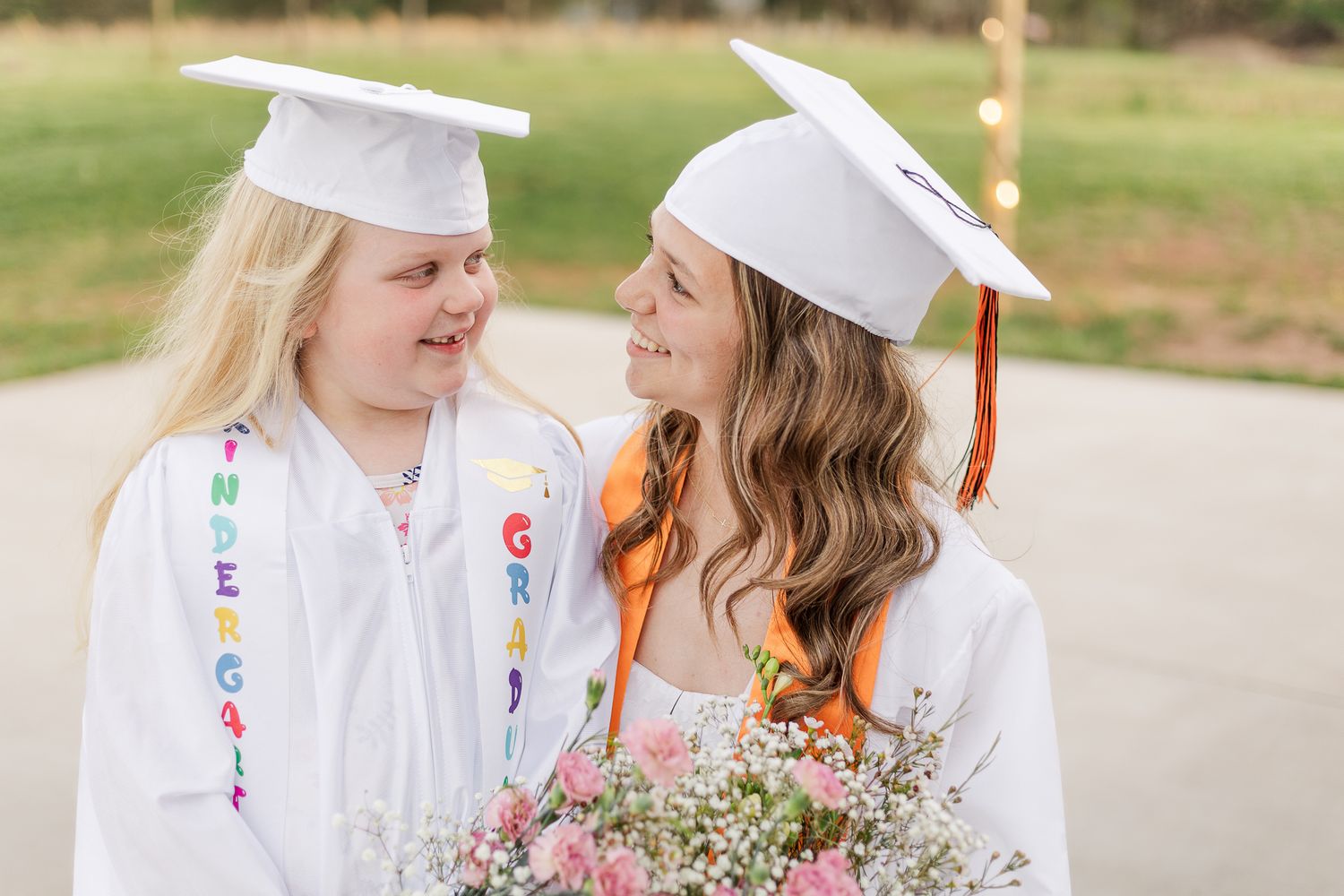 a young girl and her little sister smiling during a graduation photoshoot in nokesville virginia