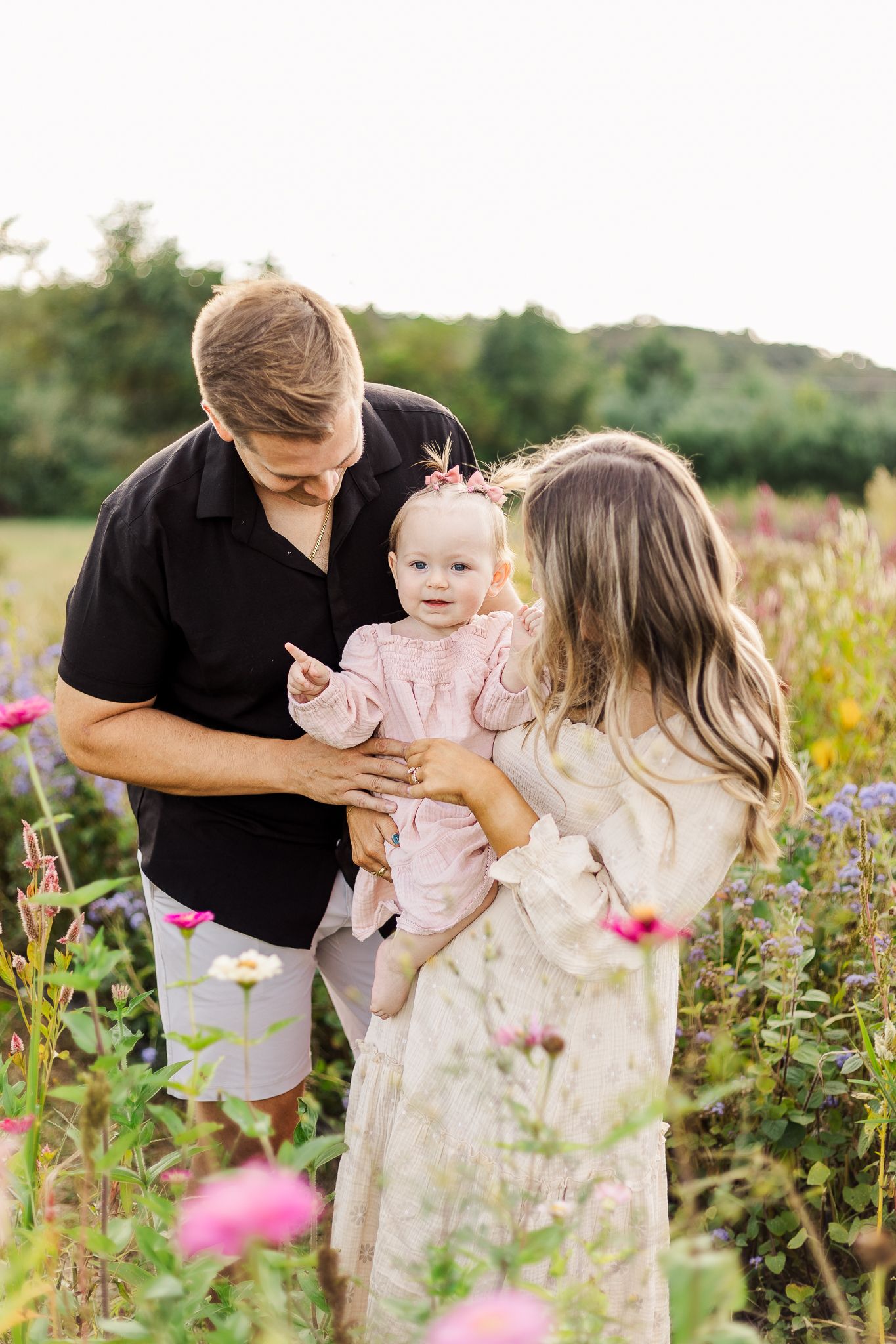 a young family smiling together in a patch of wildflowers in nokesville virginia