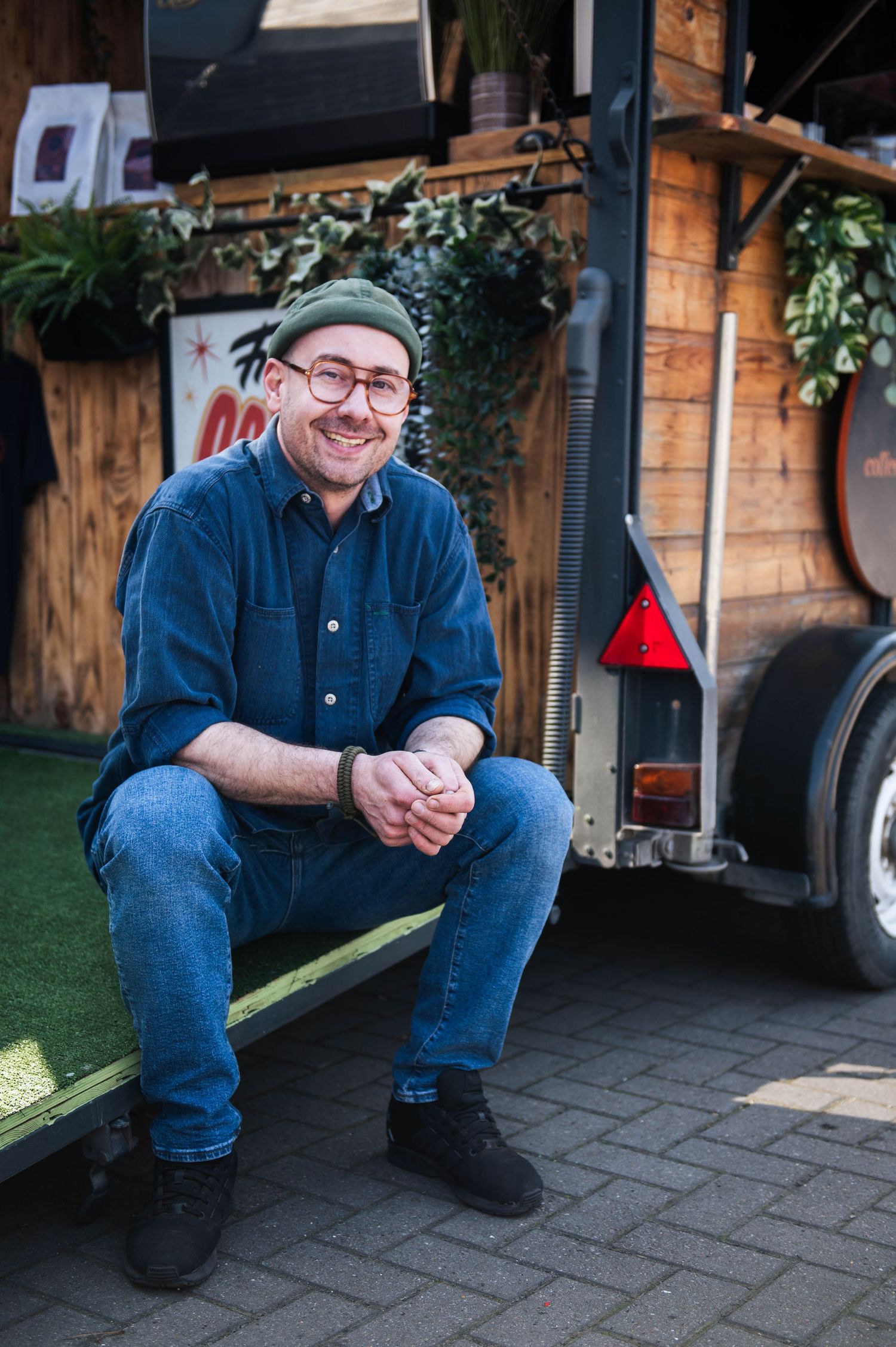 In Leeds, a coffee shop owner posing in front of his shop.