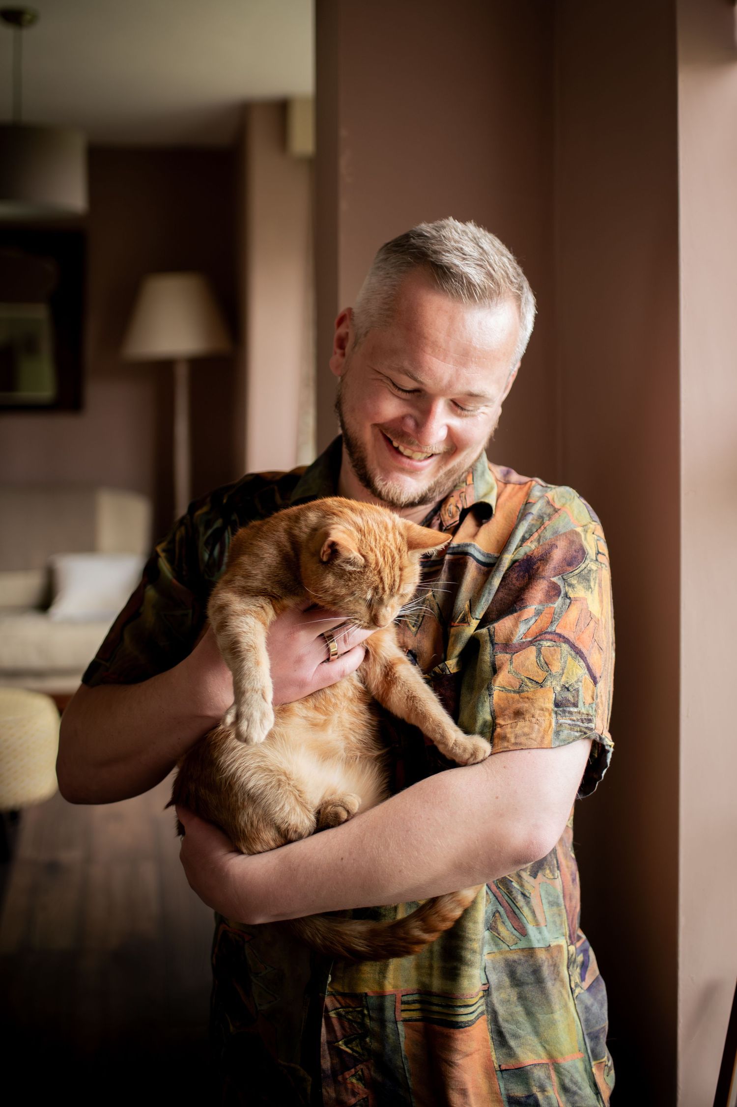 Relaxed business portraits of a Yorkshire-based accountant with an orange cat in a cozy indoor setting.