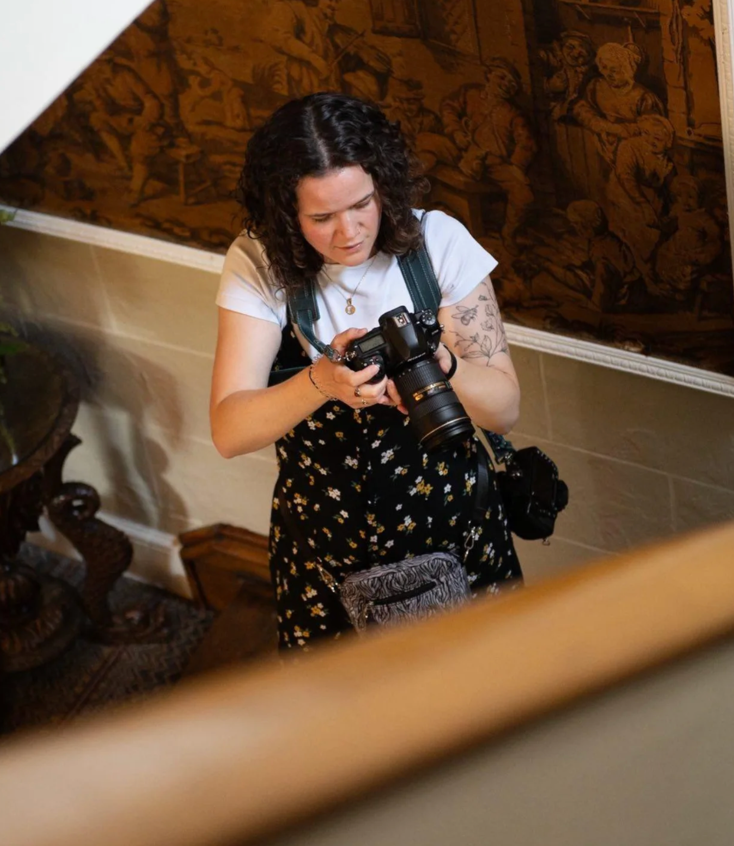 Photographer checks camera settings while working at indoor event in Yorkshire.