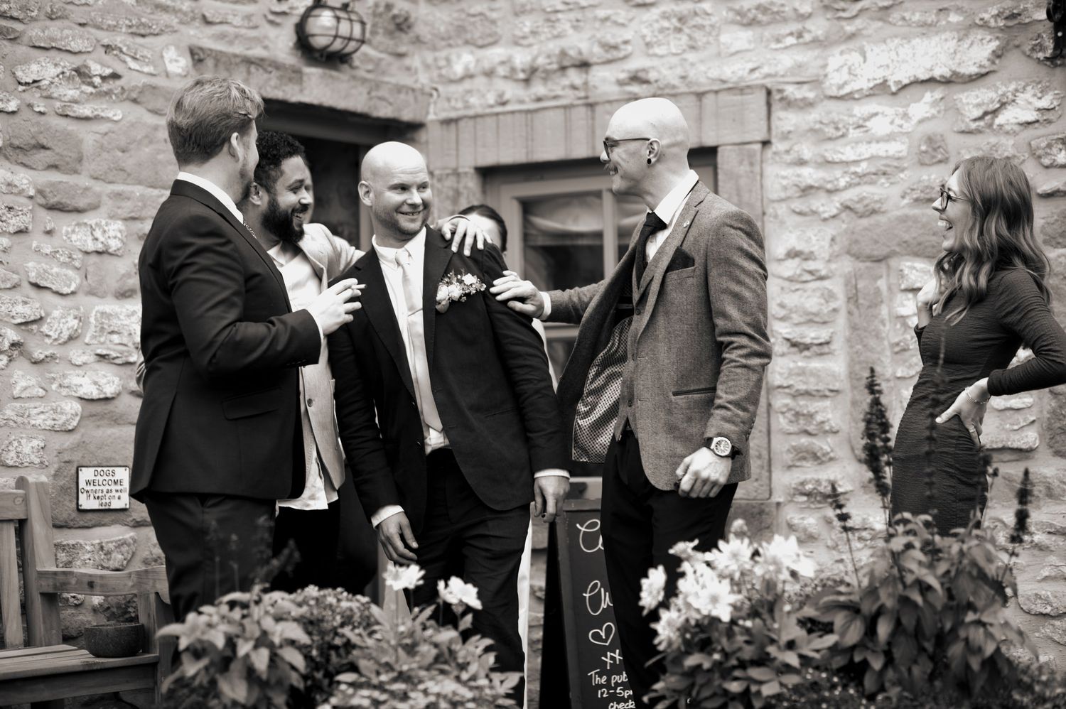 Wedding guests mingle and congratulate the groom at the wedding reception in The Blind Bull Inn, Buxton.