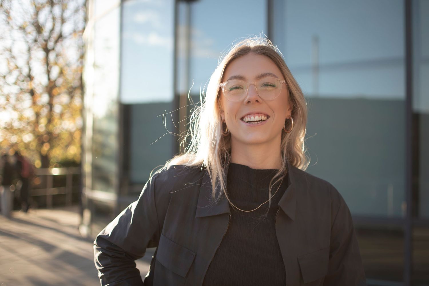 Professional portrait in outdoor setting with modern building facade, for a Leeds-based marketing business.