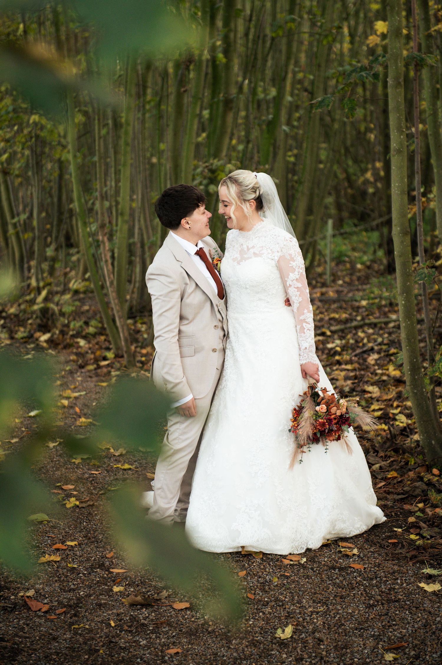 LGBT wedding couple pose on a woodland path during their couples portraits at Lodge Farm Weddings.